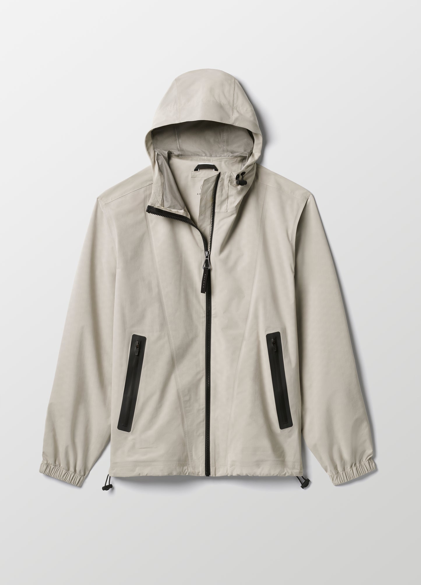 Flat lay of women’s Kite Lightweight Jacket in Stone Grey from AETHER Apparel.
