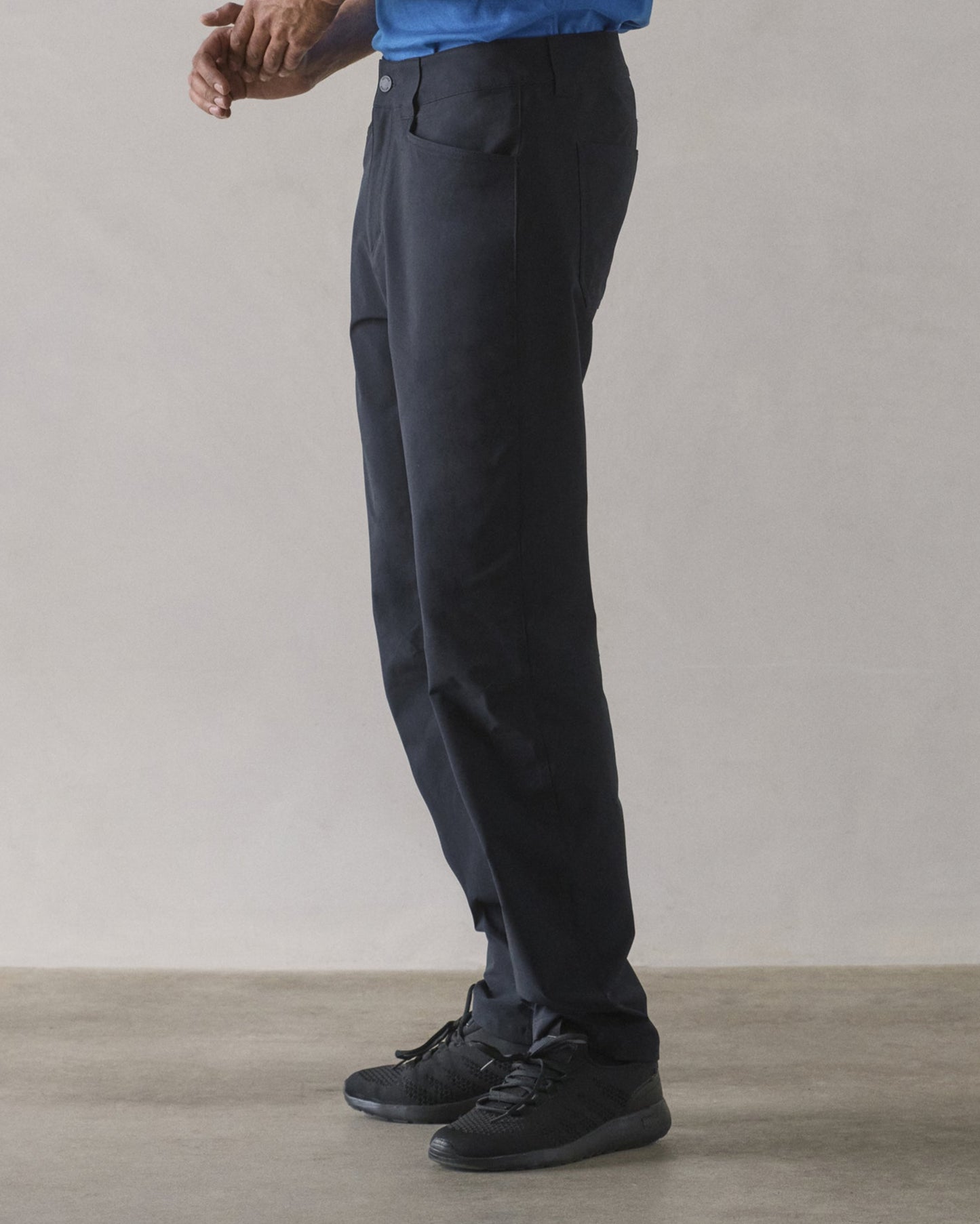 Side profile lower-body view of man wearing Adventure Pant in Onyx Black from AETHER Apparel.