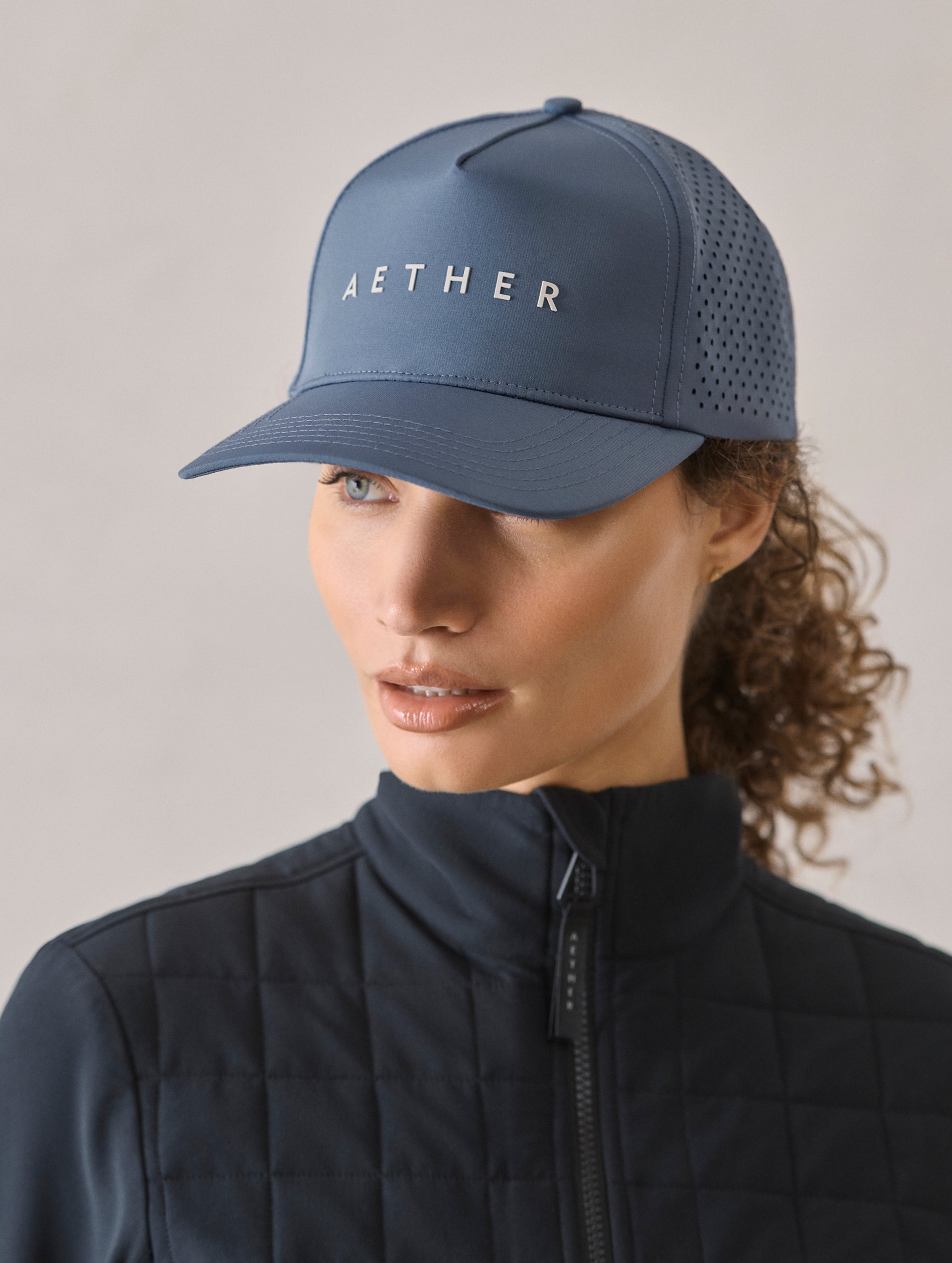 Front 3/4 view of woman wearing Adventure Mesh Hat in Portal Blue from AETHER Apparel.