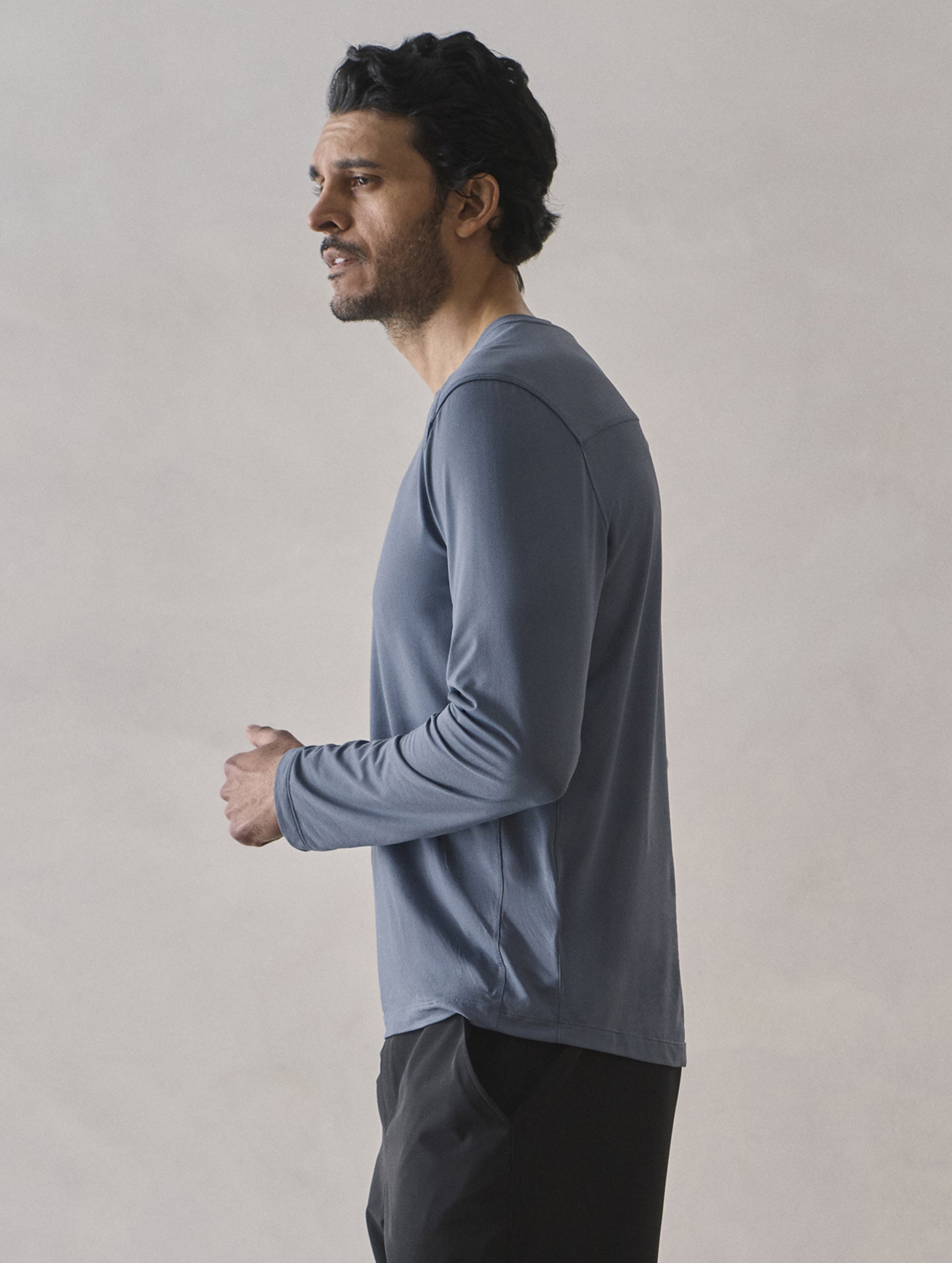 Side profile upper-body view of man wearing Adventure Performance Long-Sleeve Tee in Portal Blue from AETHER Apparel.