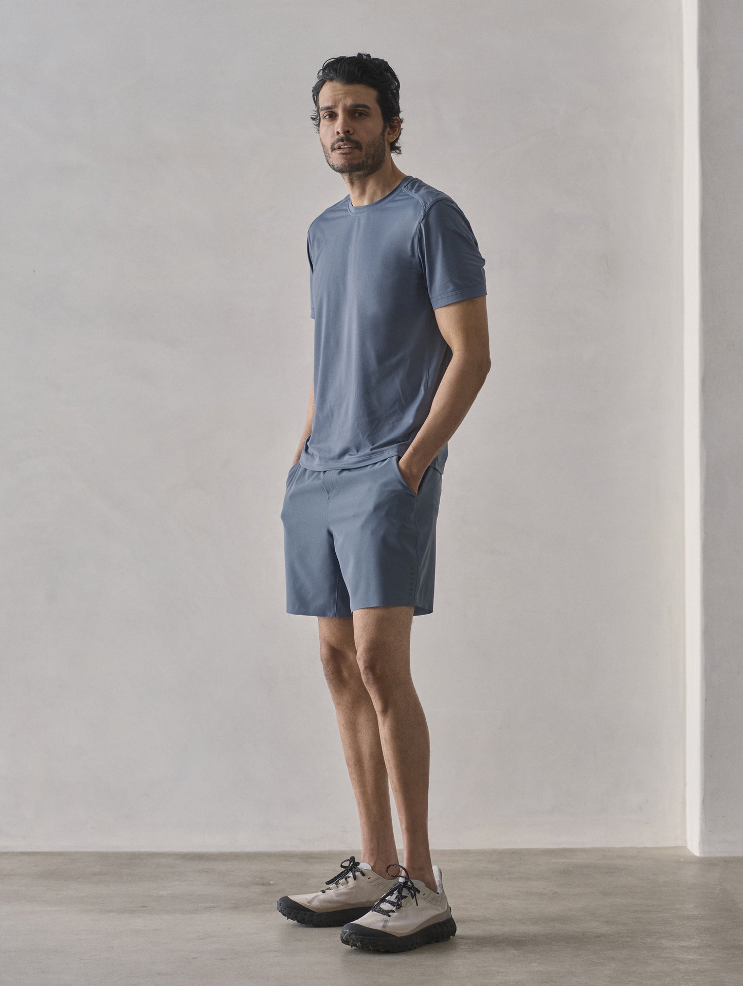 Front 3/4 full-body view of man wearing Adventure Performance Short-Sleeve Tee in Portal Blue from AETHER Apparel.