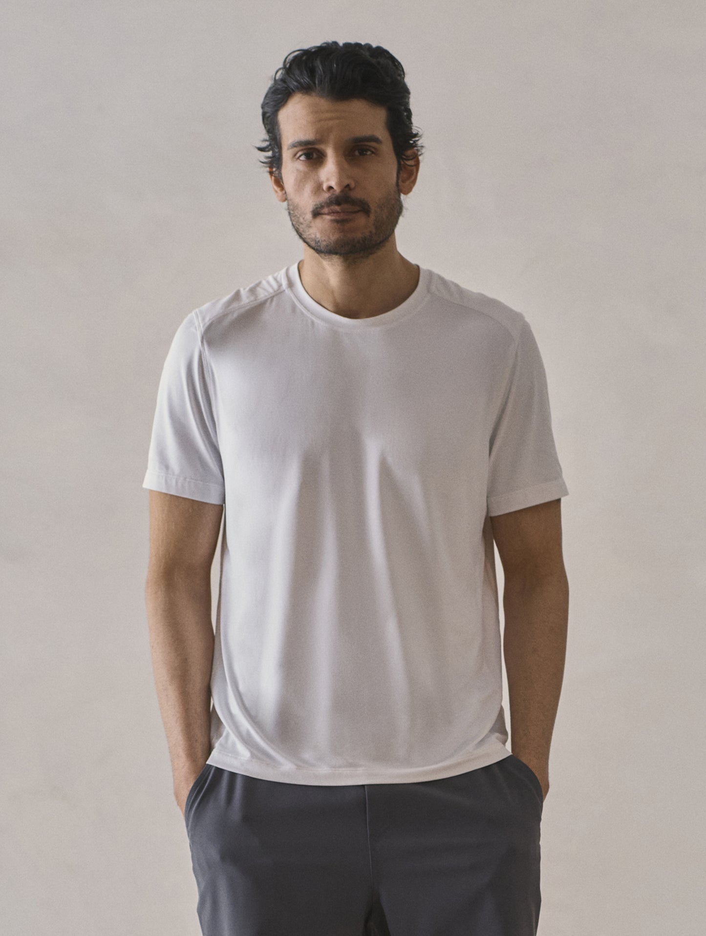 Front upper-body view of man wearing Adventure Performance Short-Sleeve Tee in White from AETHER Apparel.
