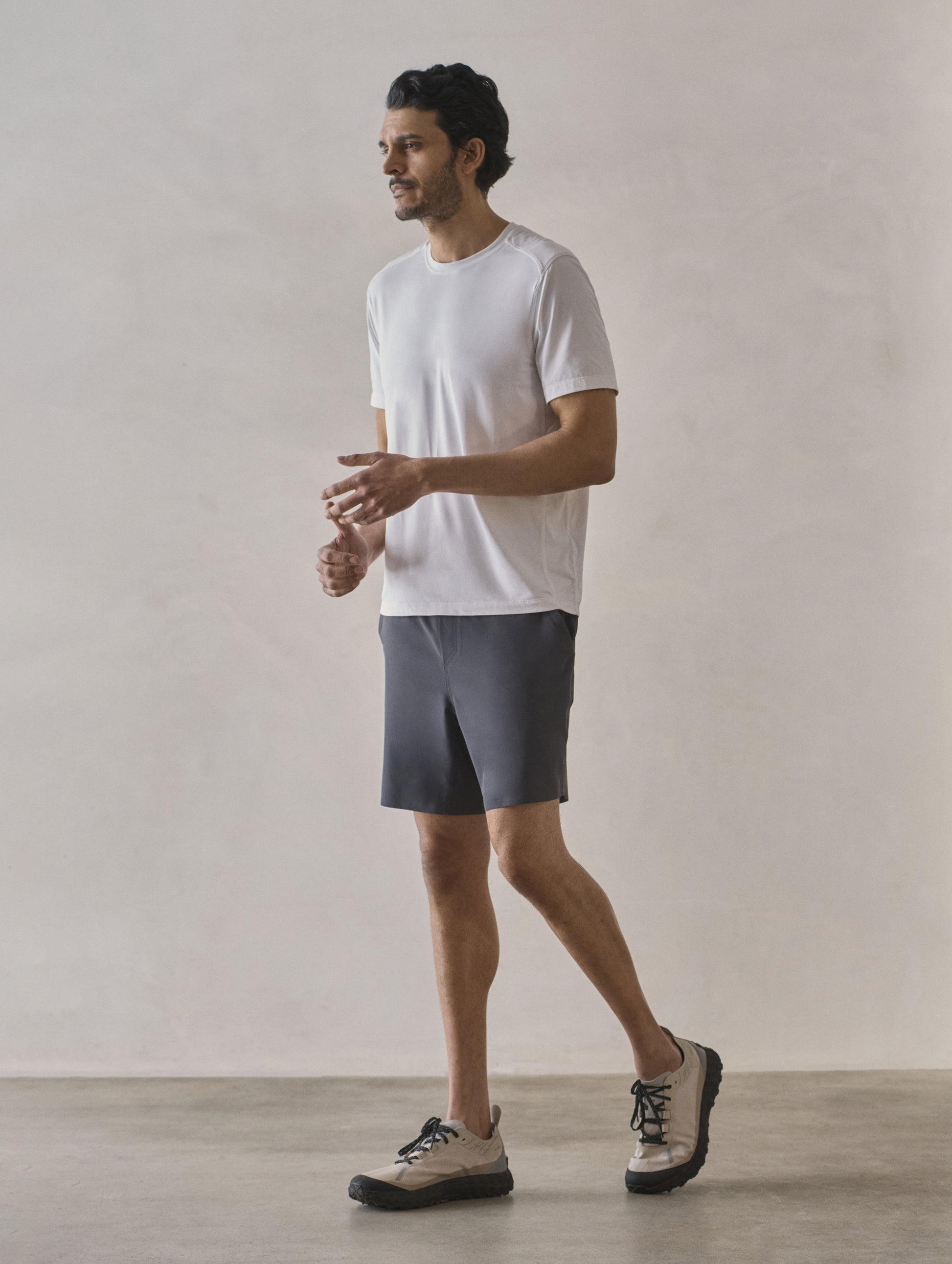 Front 3/4 full-body view of man wearing Adventure Performance Short-Sleeve Tee in White from AETHER Apparel.