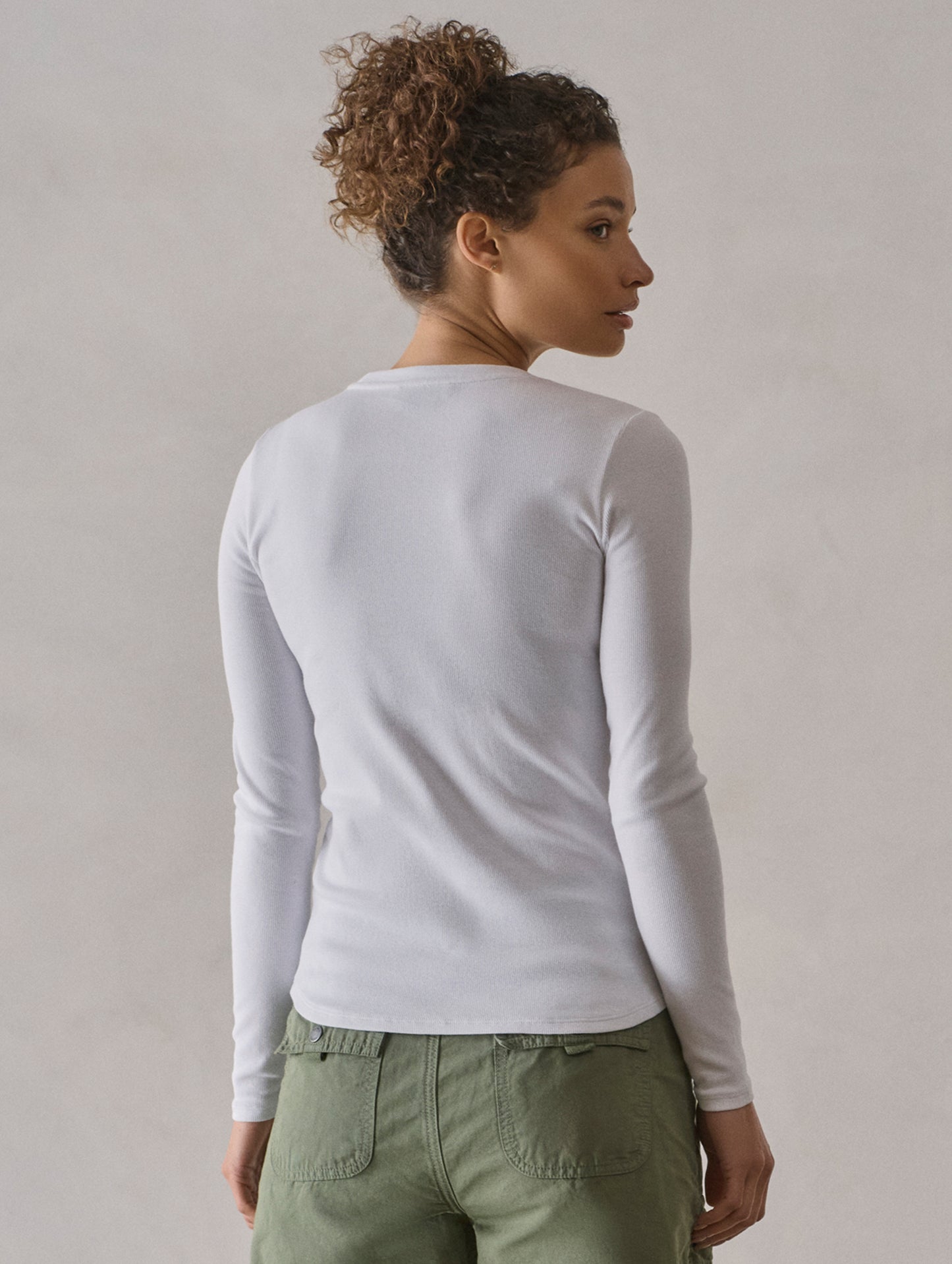 Rear view of woman wearing Amara Long-Sleeve Crew in White from AETHER Apparel.