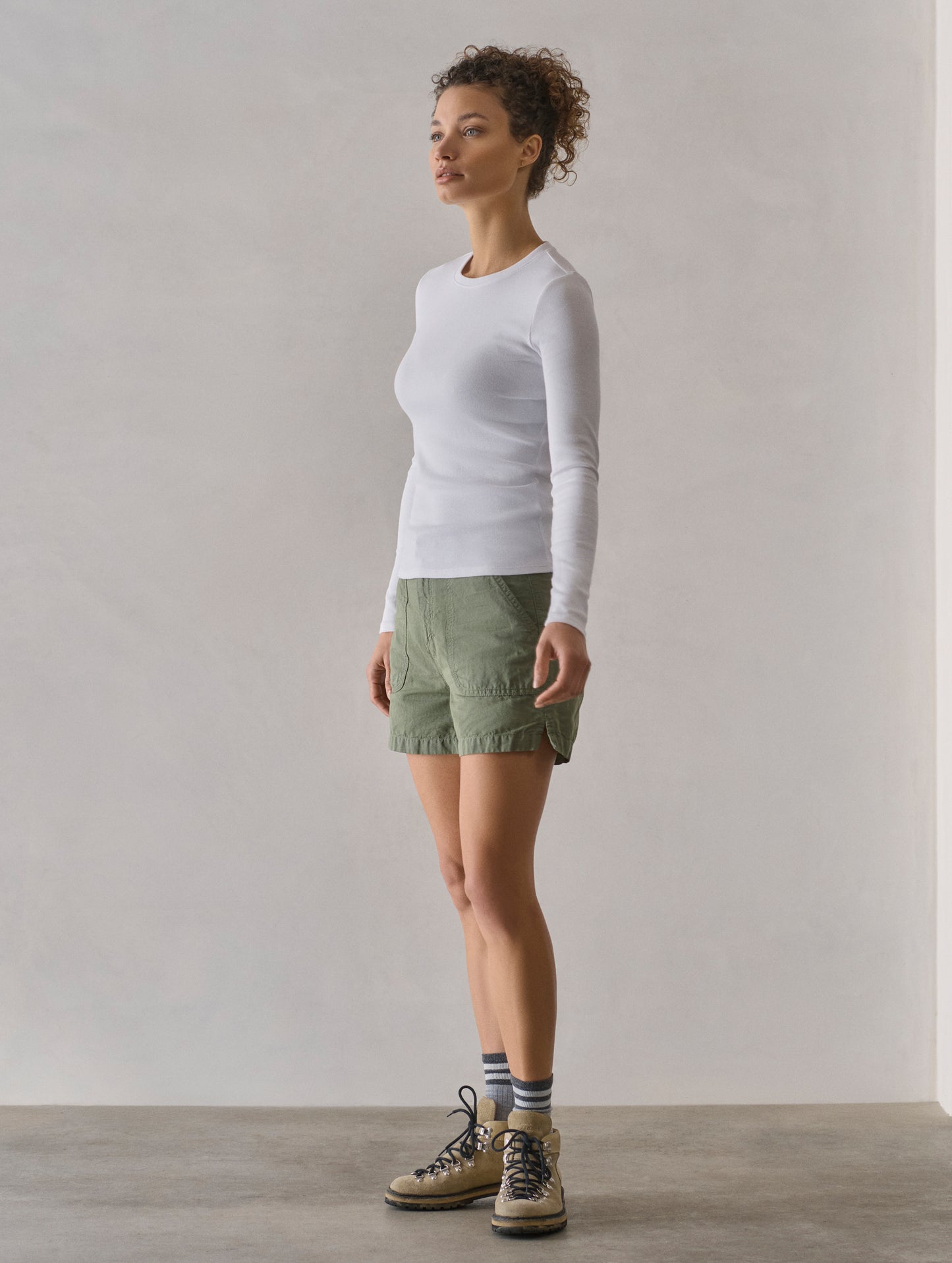 Front 3/4 full-body view of woman wearing Amara Long-Sleeve Crew in White from AETHER Apparel.