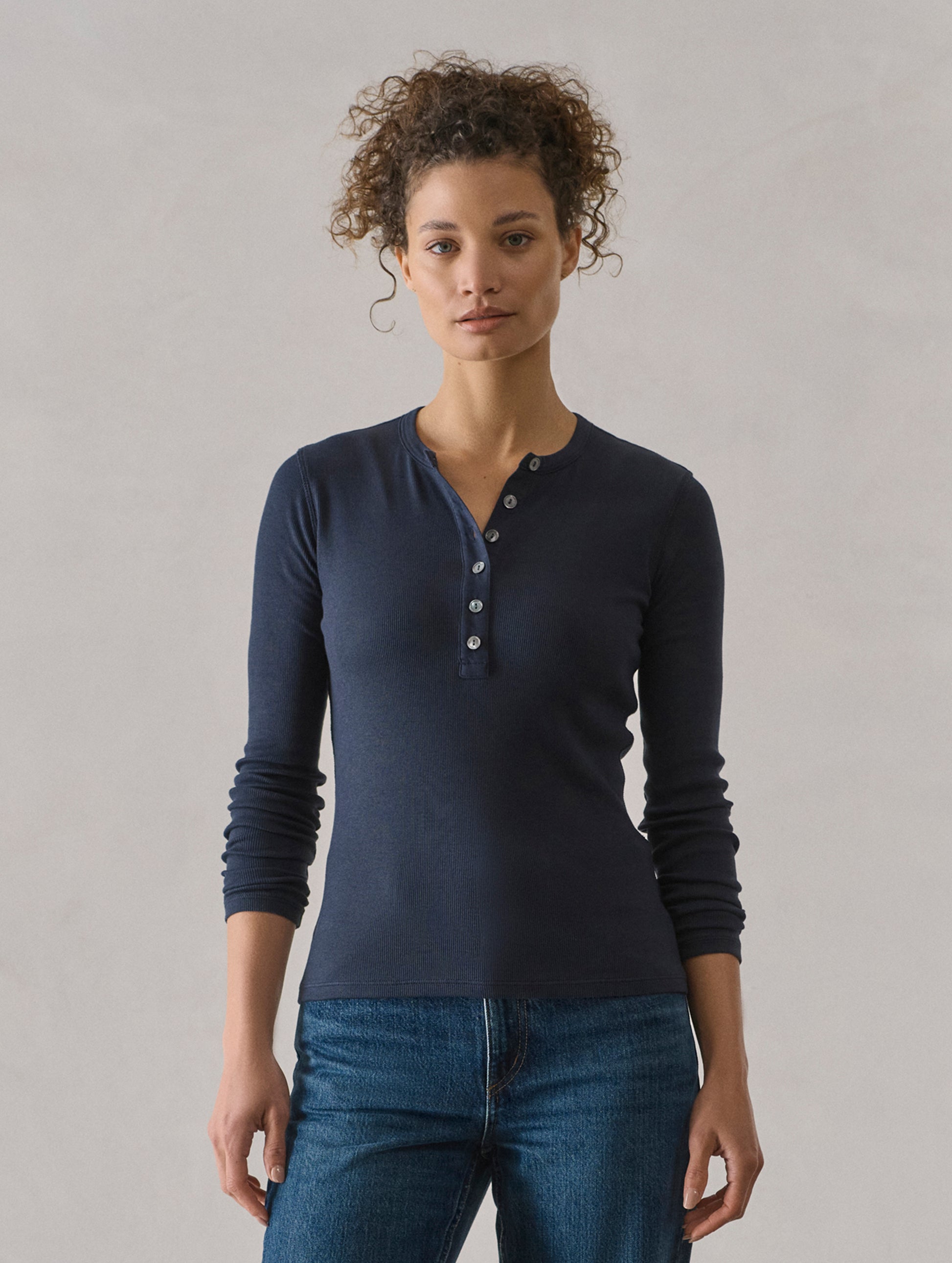 Front view of woman wearing Amara Long-Sleeve Ribbed Henley in Total Eclipse dark blue from AETHER Apparel.