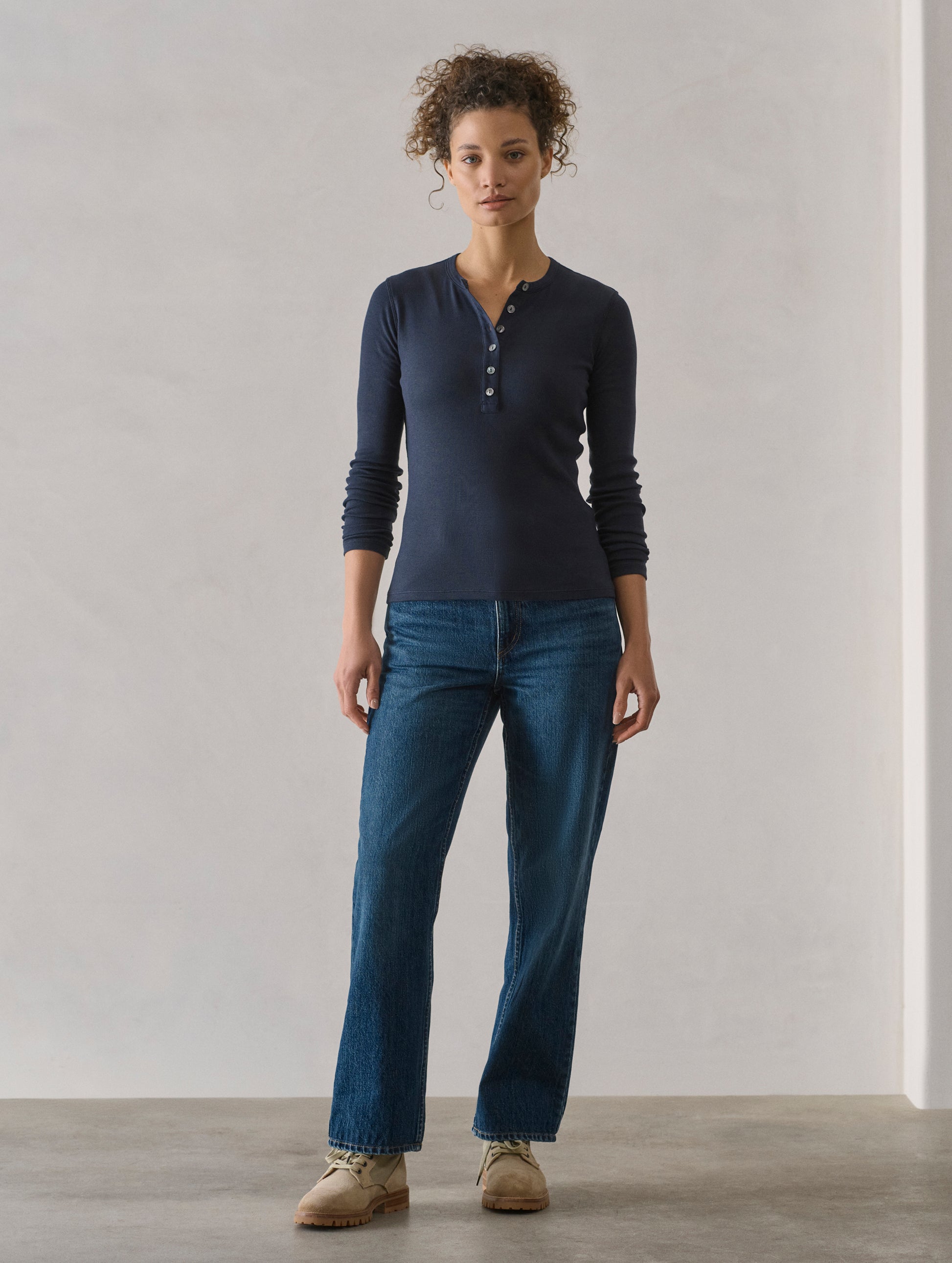 Front full-body view of woman wearing Amara Long-Sleeve Ribbed Henley in Total Eclipse dark blue from AETHER Apparel.