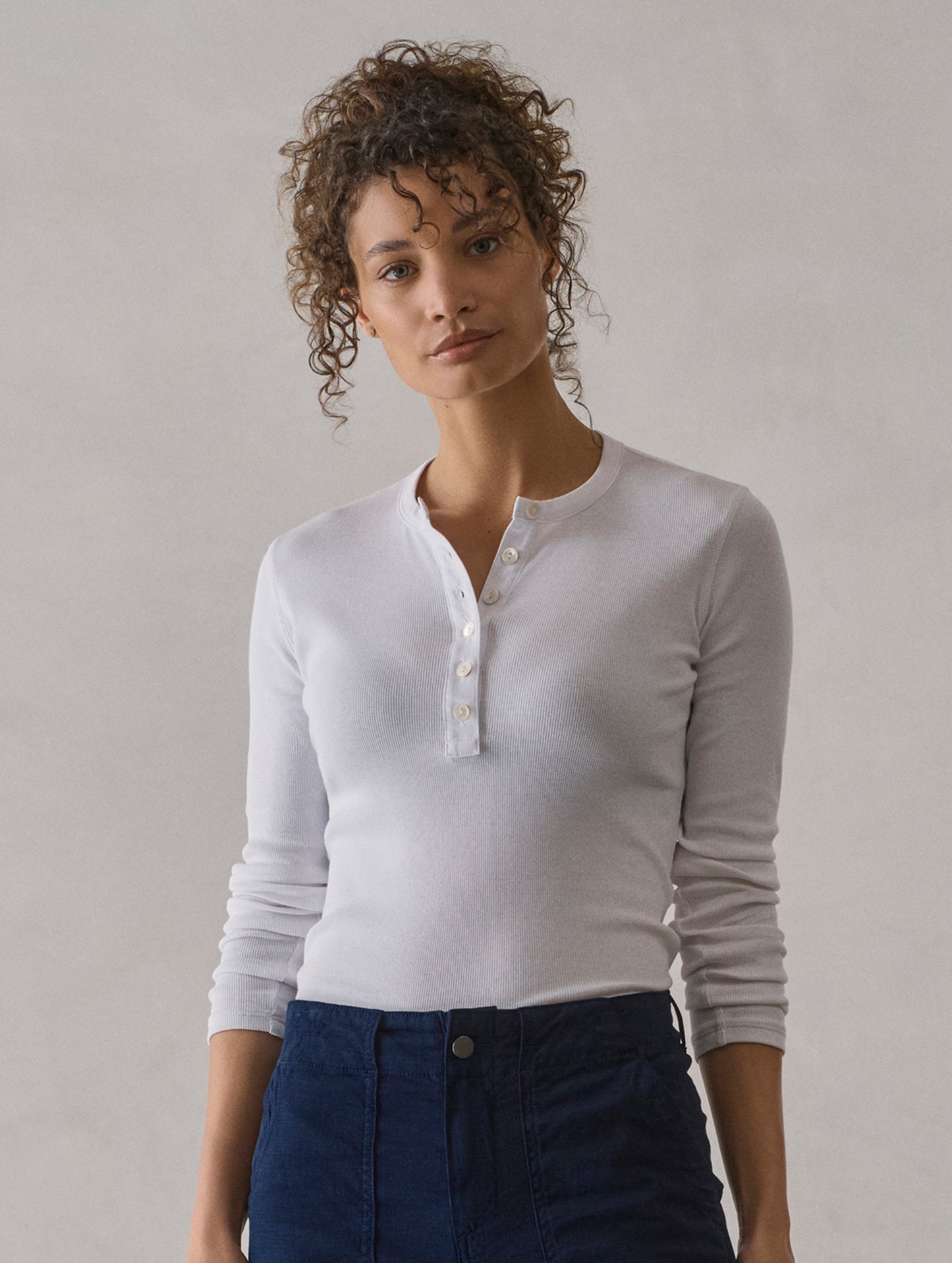 Front view of woman wearing Amara Long-Sleeve Ribbed Henley in White from AETHER Apparel.