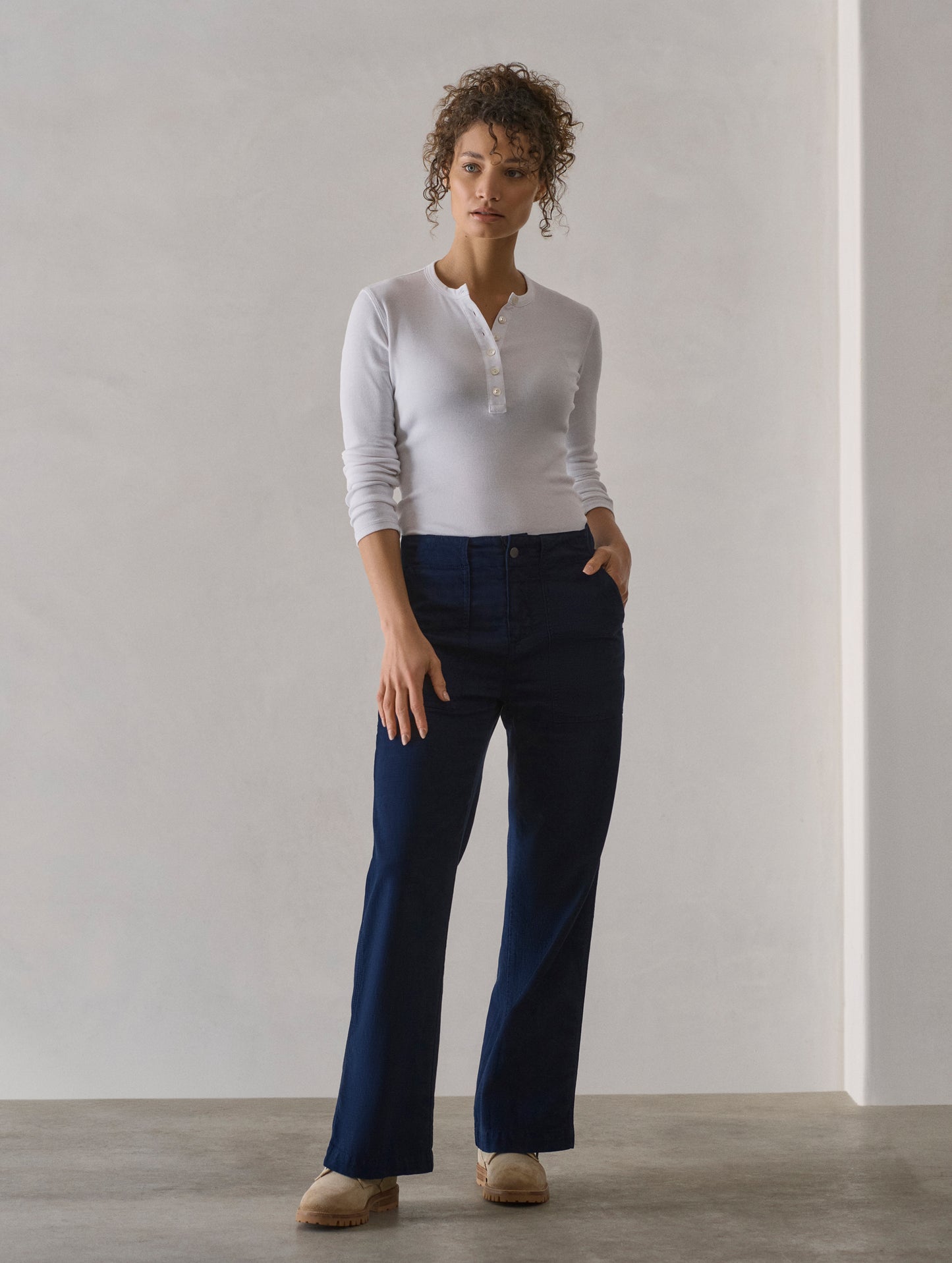 Front full-body view of woman wearing Amara Long-Sleeve Ribbed Henley in White from AETHER Apparel.