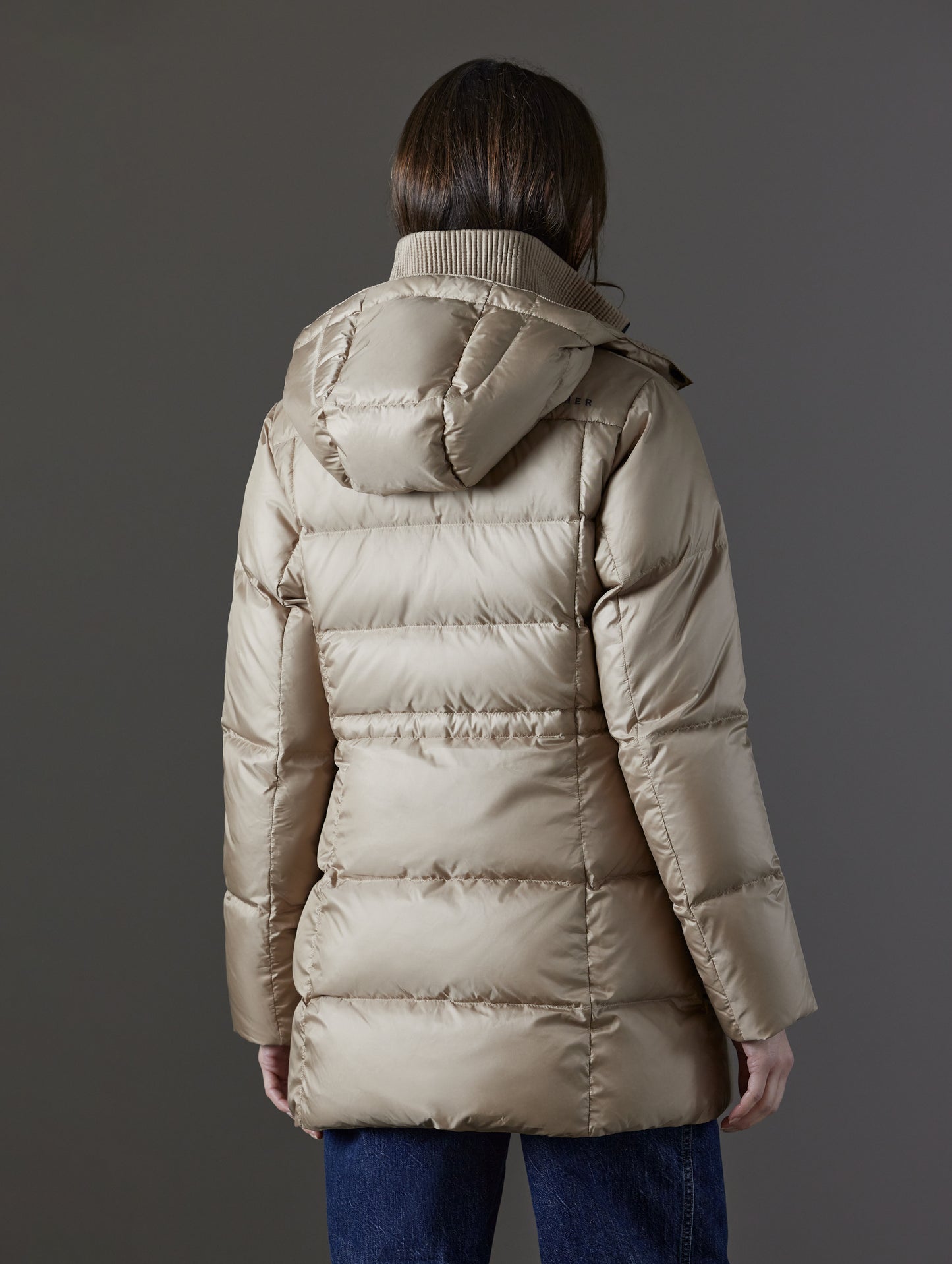 Rear angled view of woman wearing Aura Puffer Long in Chinchilla Brown from AETHER Apparel.