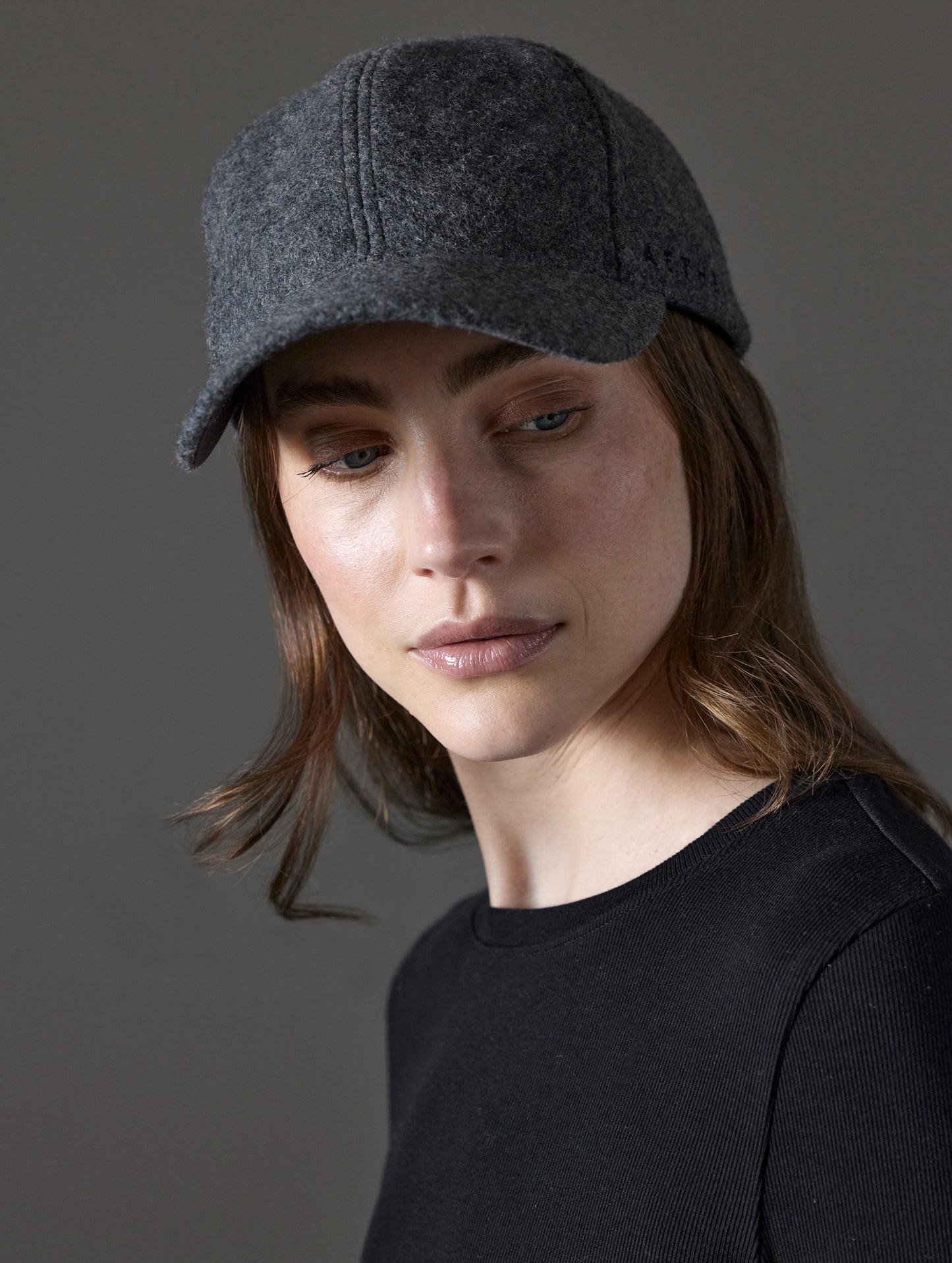 Front angled view of woman wearing AETHER Wool Hat in Charcoal Heather from AETHER Apparel.