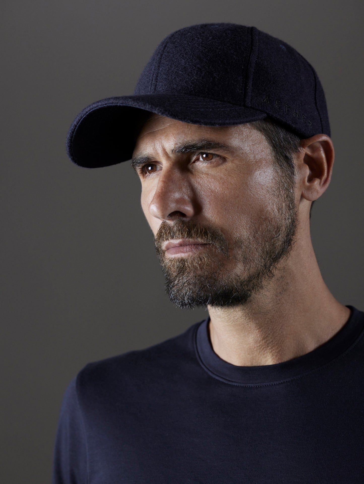 Front angled view of man wearing AETHER Wool Hat in Total Eclipse dark blue from AETHER Apparel.