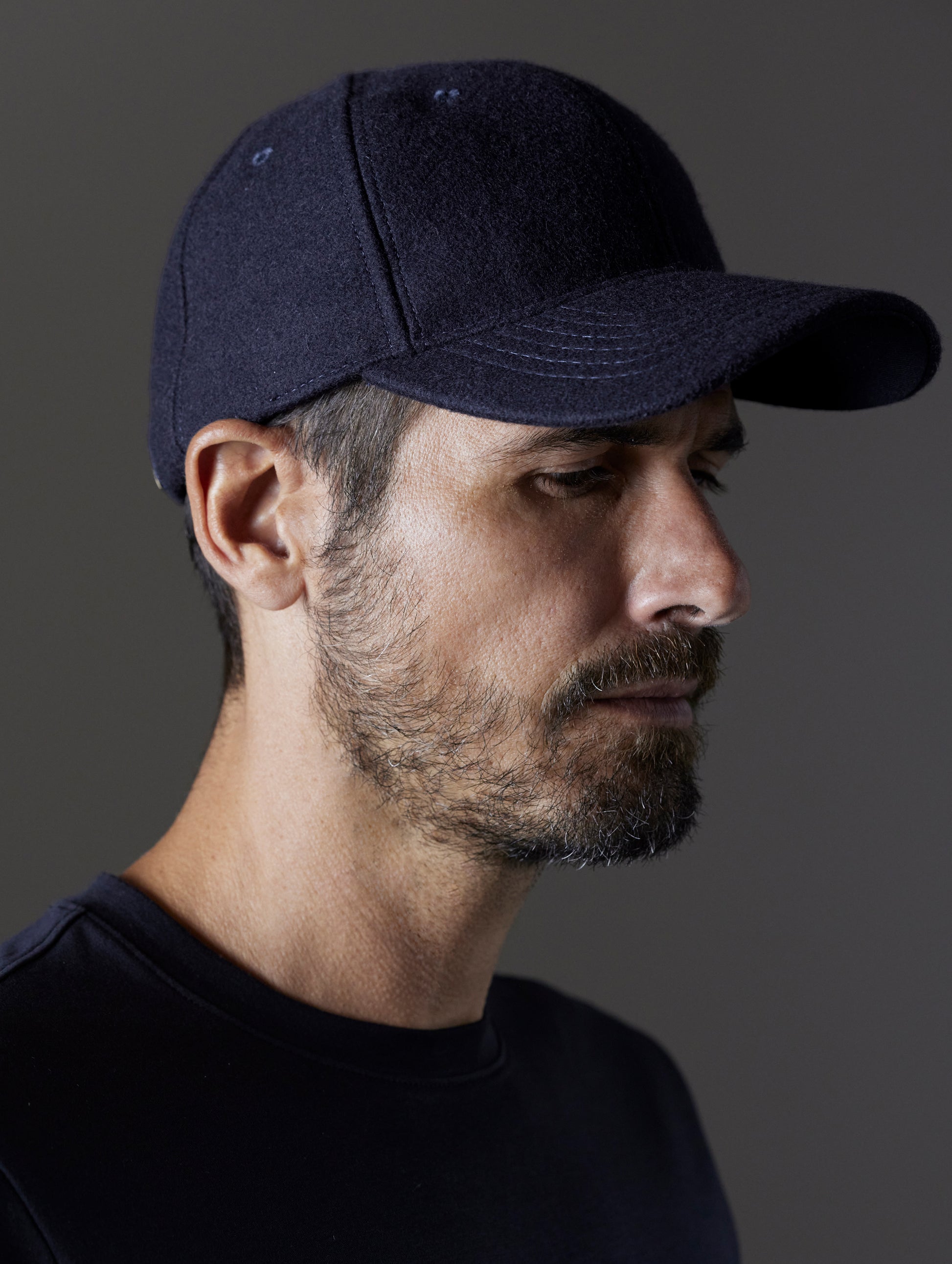 Right side angled view of man wearing AETHER Wool Hat in Total Eclipse dark blue from AETHER Apparel.