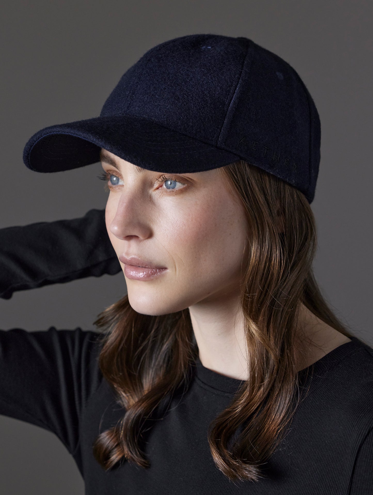 Front angled view of woman wearing AETHER Wool Hat in Total Eclipse dark blue from AETHER Apparel.