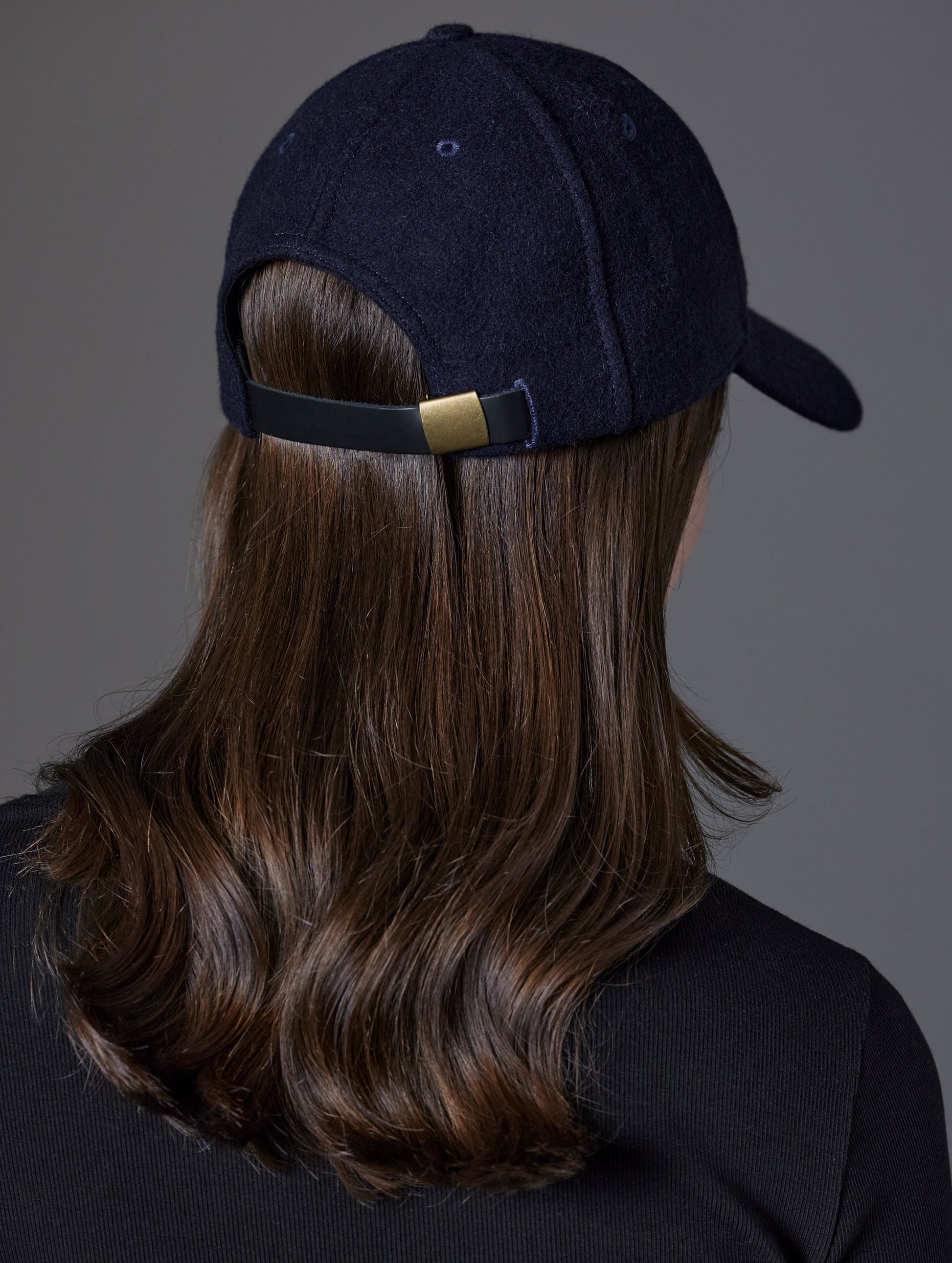 Rear angled view of woman wearing AETHER Wool Hat in Total Eclipse dark blue from AETHER Apparel.