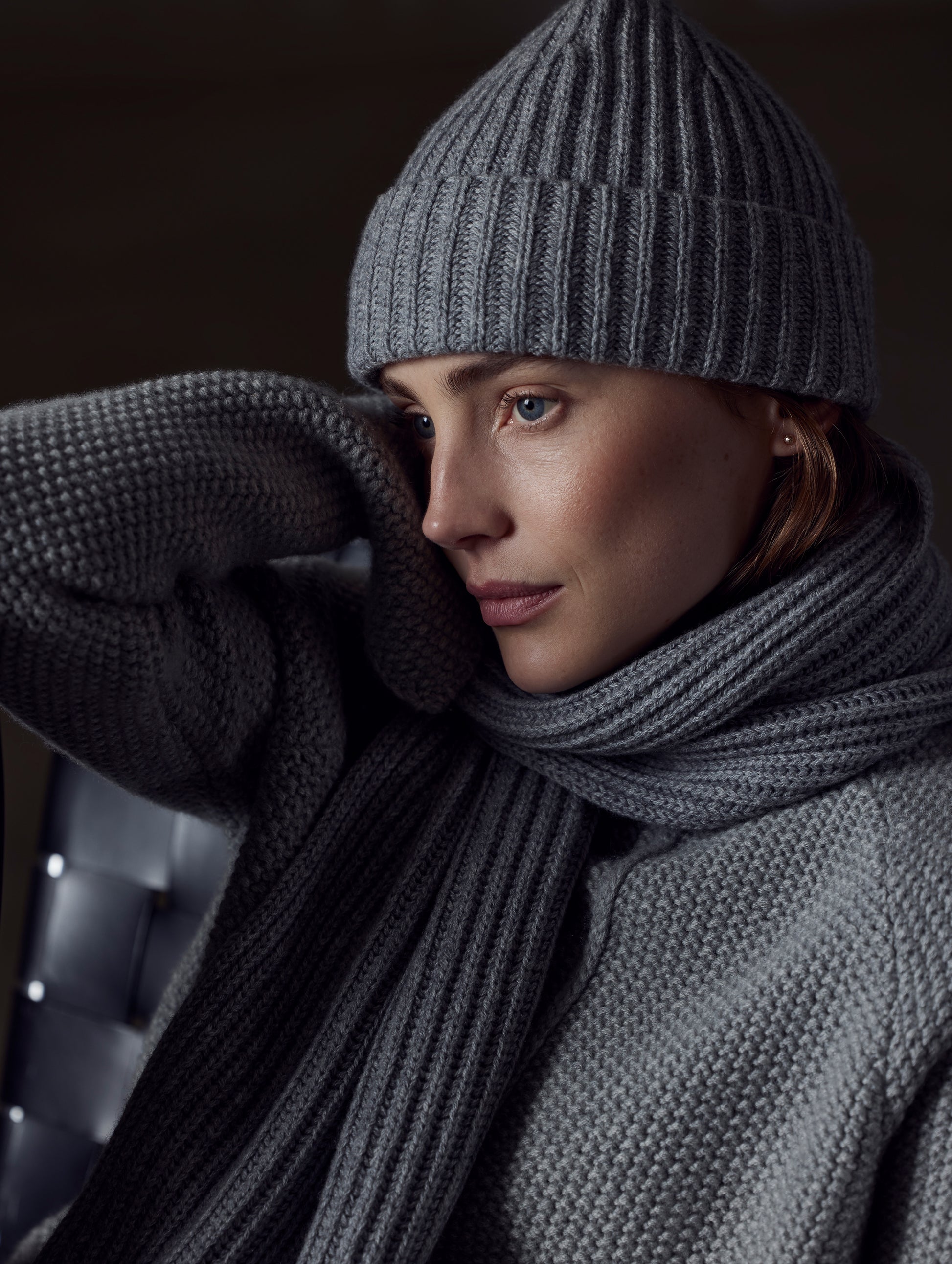Front angled view of woman holding leather bag wearing Cashmere Hat in Heather Grey from AETHER Apparel.