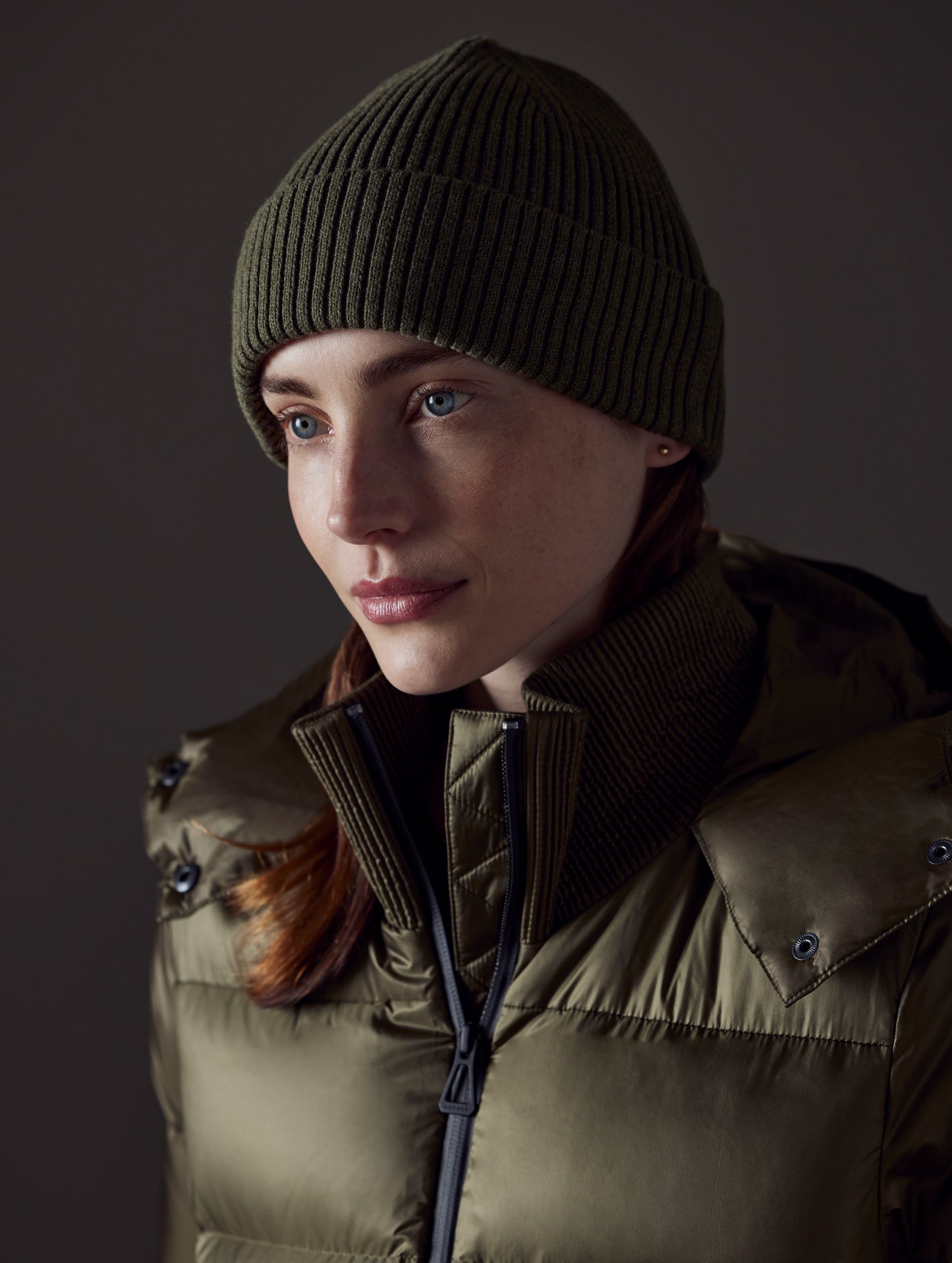 Front angled view of woman wearing Chalet Cotton Beanie in Command Green Heather from AETHER Apparel.