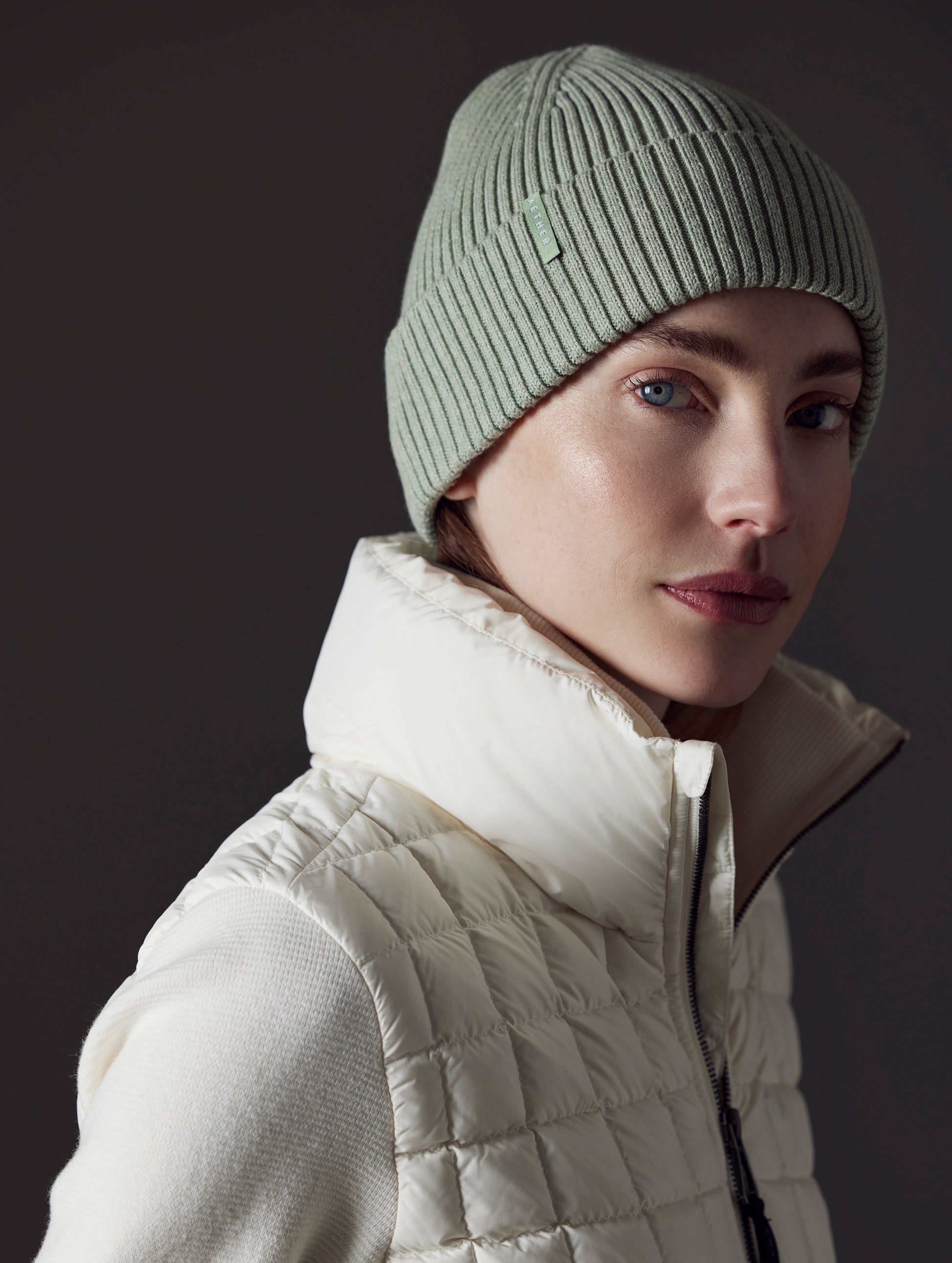 Front angled view of woman wearing Chalet Cotton Beanie in Mineral Green Heather from AETHER Apparel.