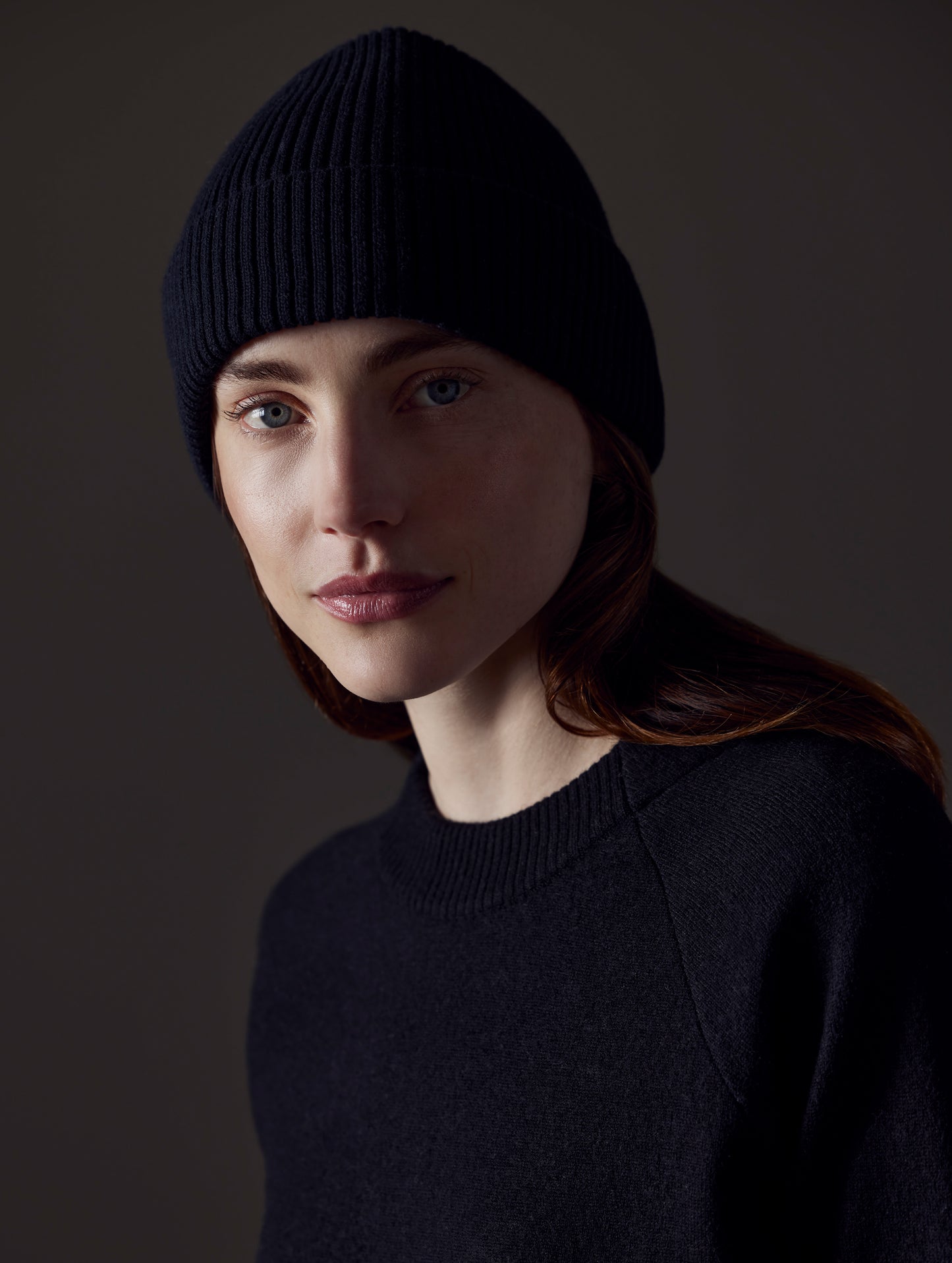 Front angled view of woman wearing Chalet Cotton Beanie in Onyx Black from AETHER Apparel.