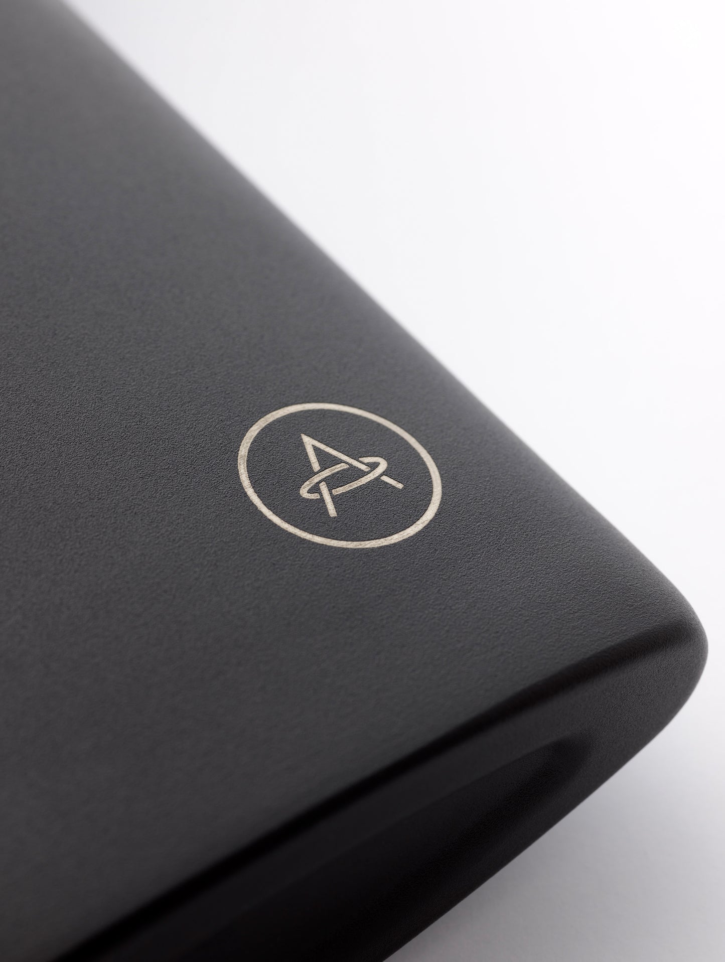 Closeup detailed view of AETHER logo on bottom corner of AETHER + Miir Aero Flask in Black with top open.
