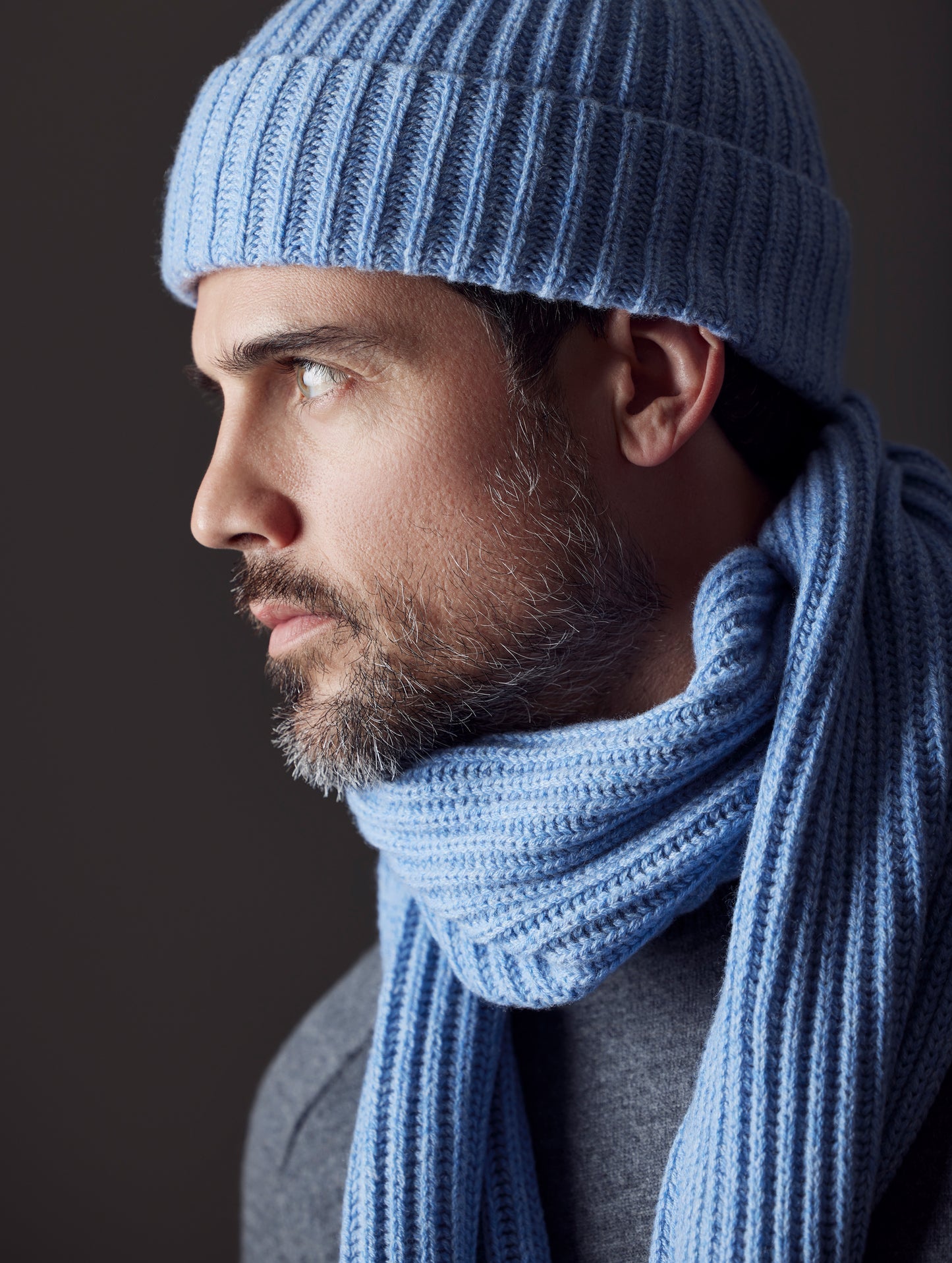 Closeup side profile view of man wearing Ribbed Cashmere Scarf in Light Blue Heather from AETHER Apparel.