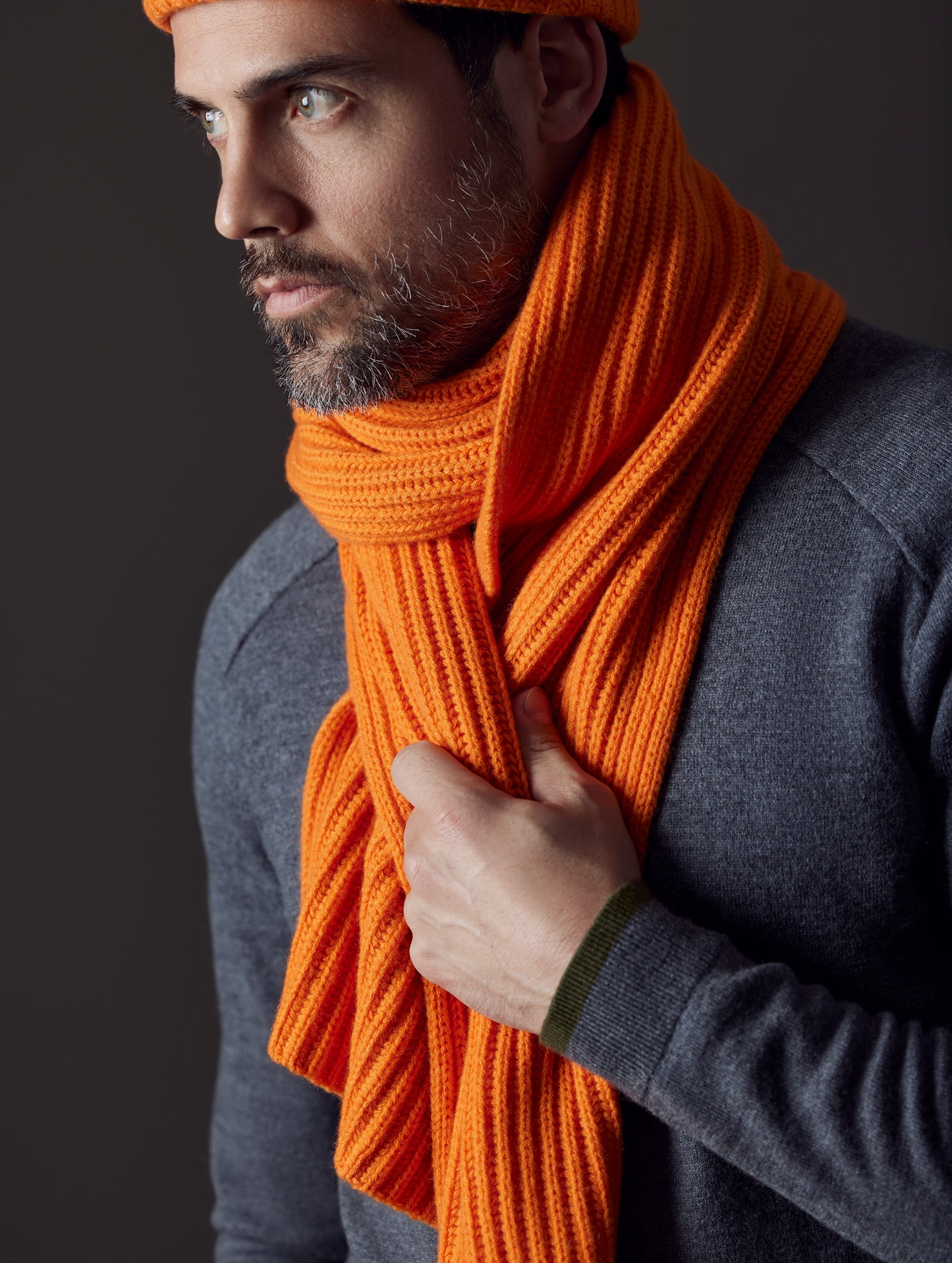 Front view of man wearing Ribbed Cashmere Scarf in Bitter Orange from AETHER Apparel.