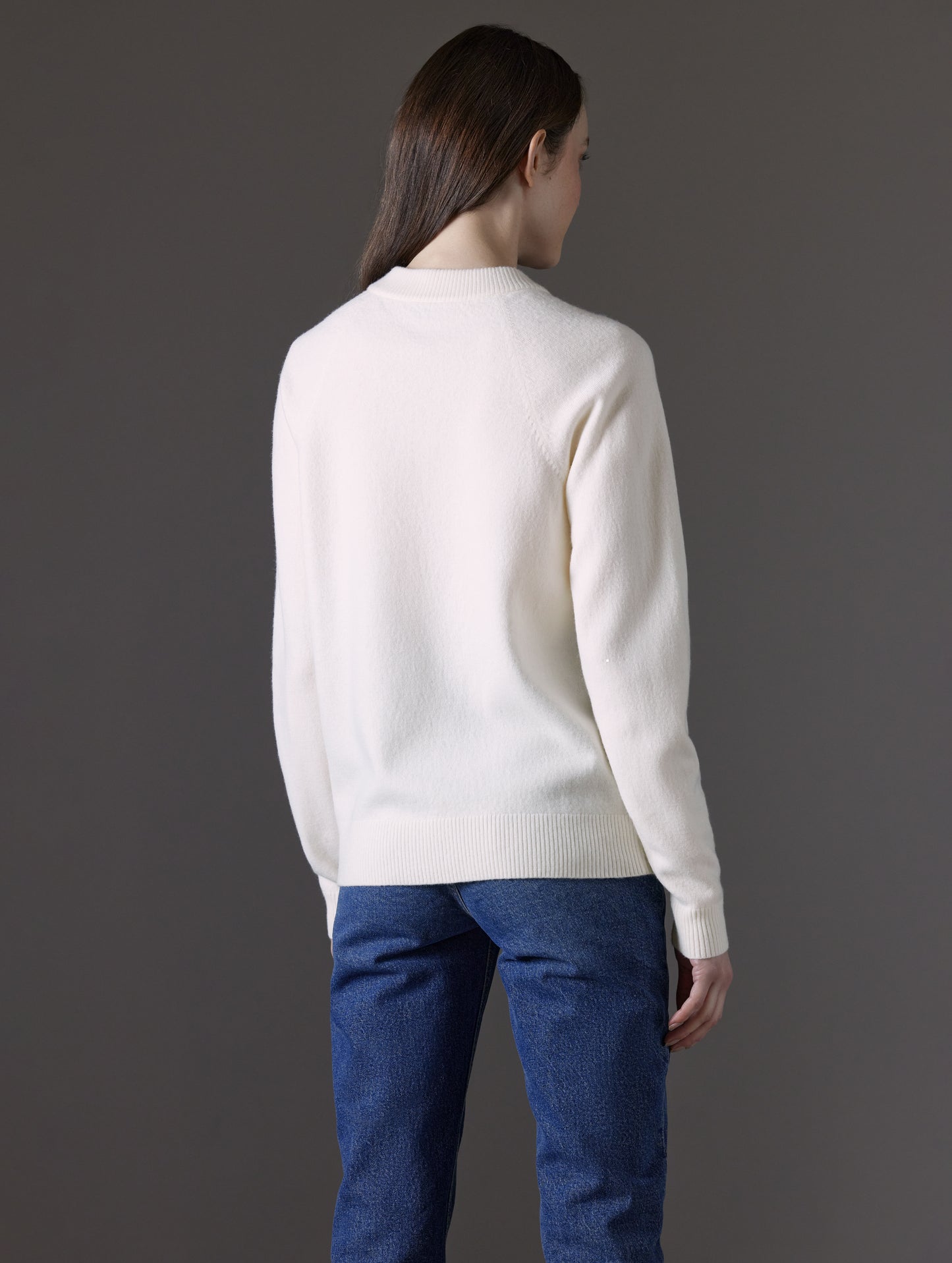 Rear angled view of woman wearing Bridget Sweater in Winter White from AETHER Apparel.