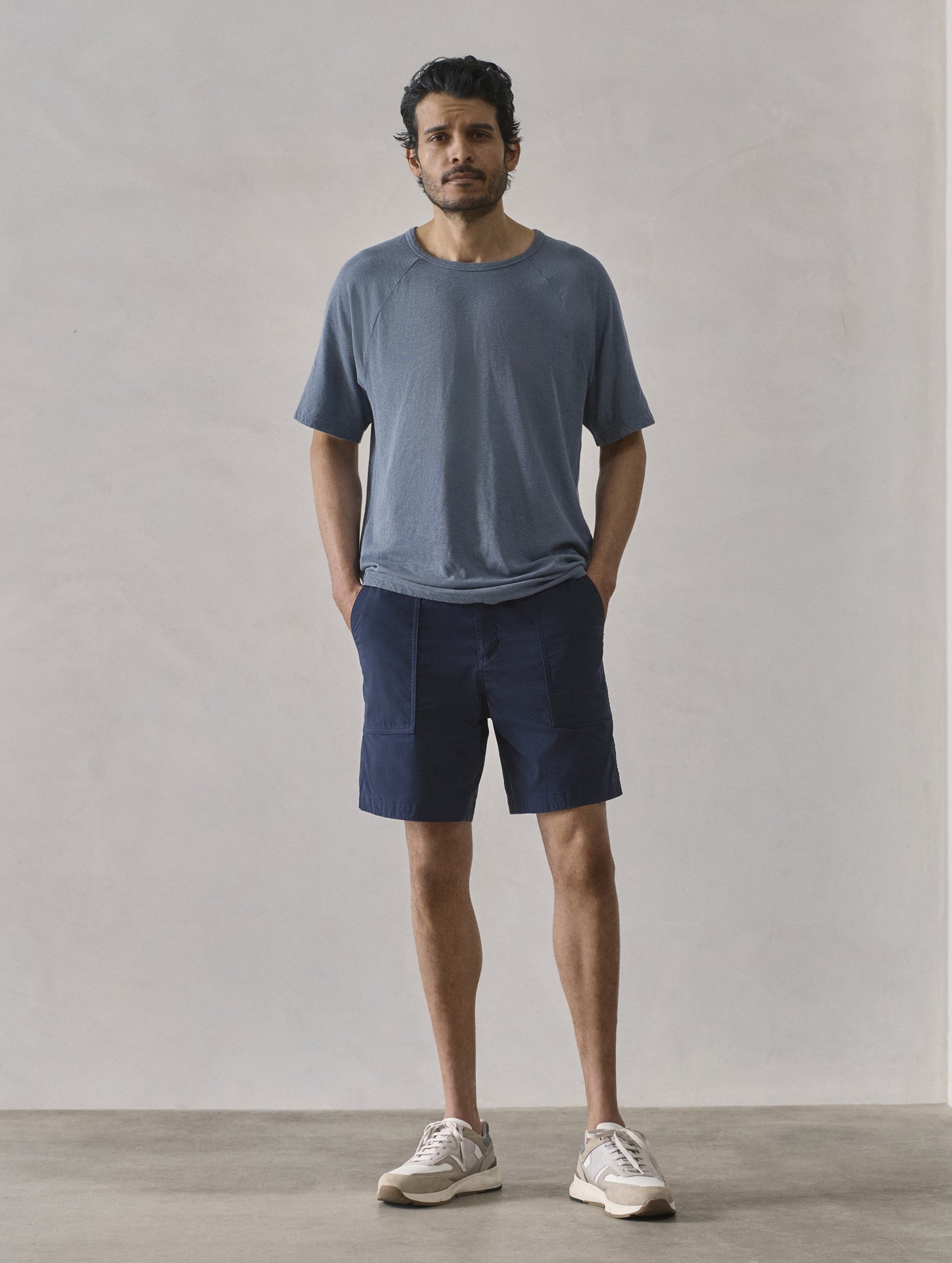 Front full-body view of man wearing Buckhorn Cotton Raglan Tee 2.0 in Portal Blue from AETHER Apparel.
