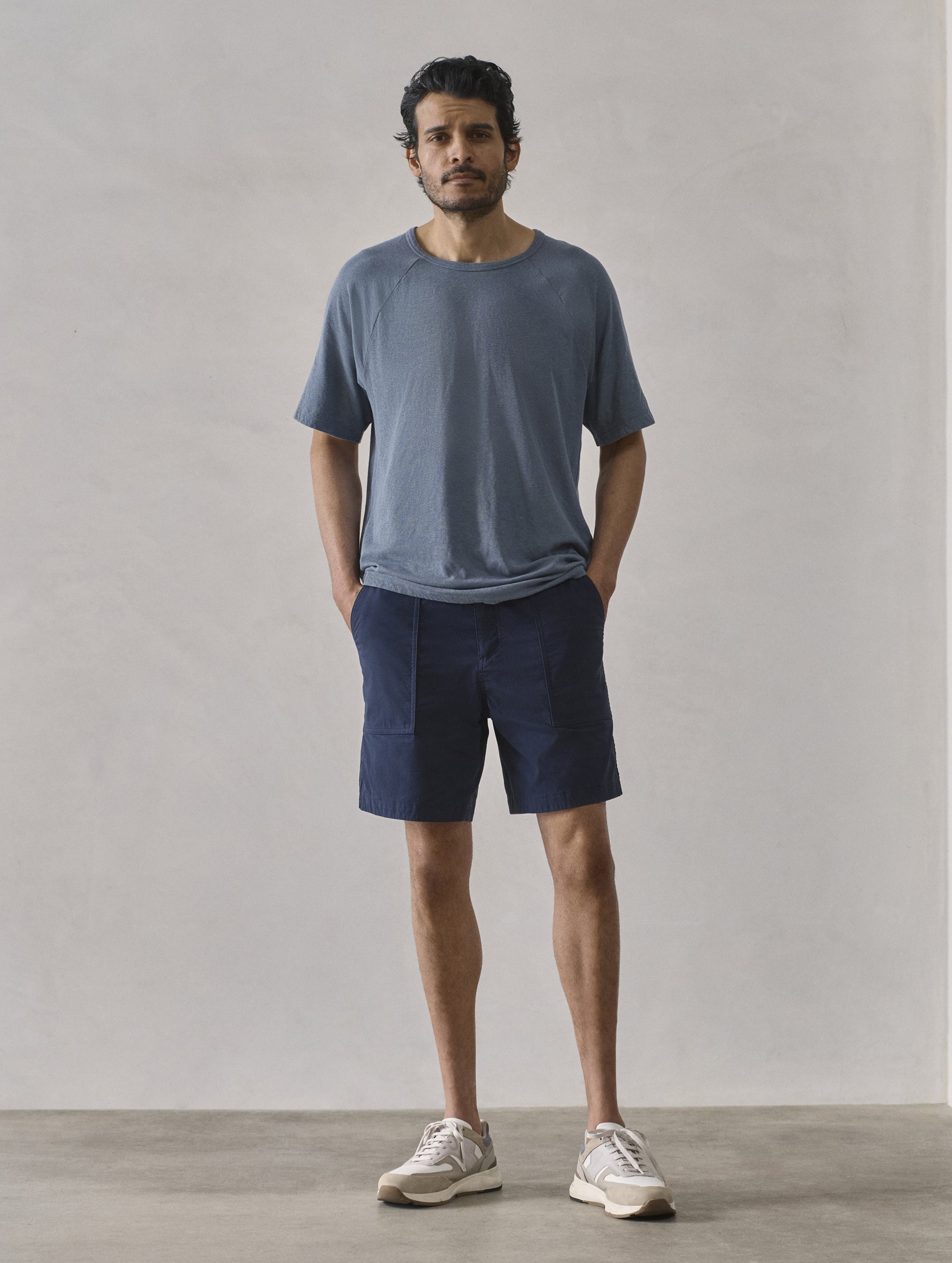 Front full-body view of man wearing Buckhorn Cotton Raglan Tee 2.0 in Portal Blue from AETHER Apparel.