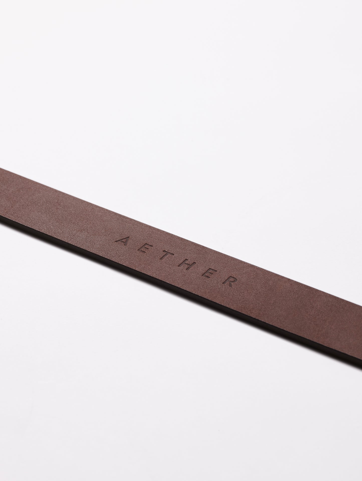 AETHER logo on strap of brown Canyon Leather Belt from AETHER Apparel