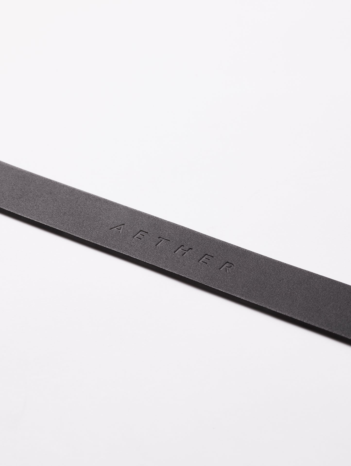AETHER logo on strap of black Canyon Leather Belt from AETHER Apparel.