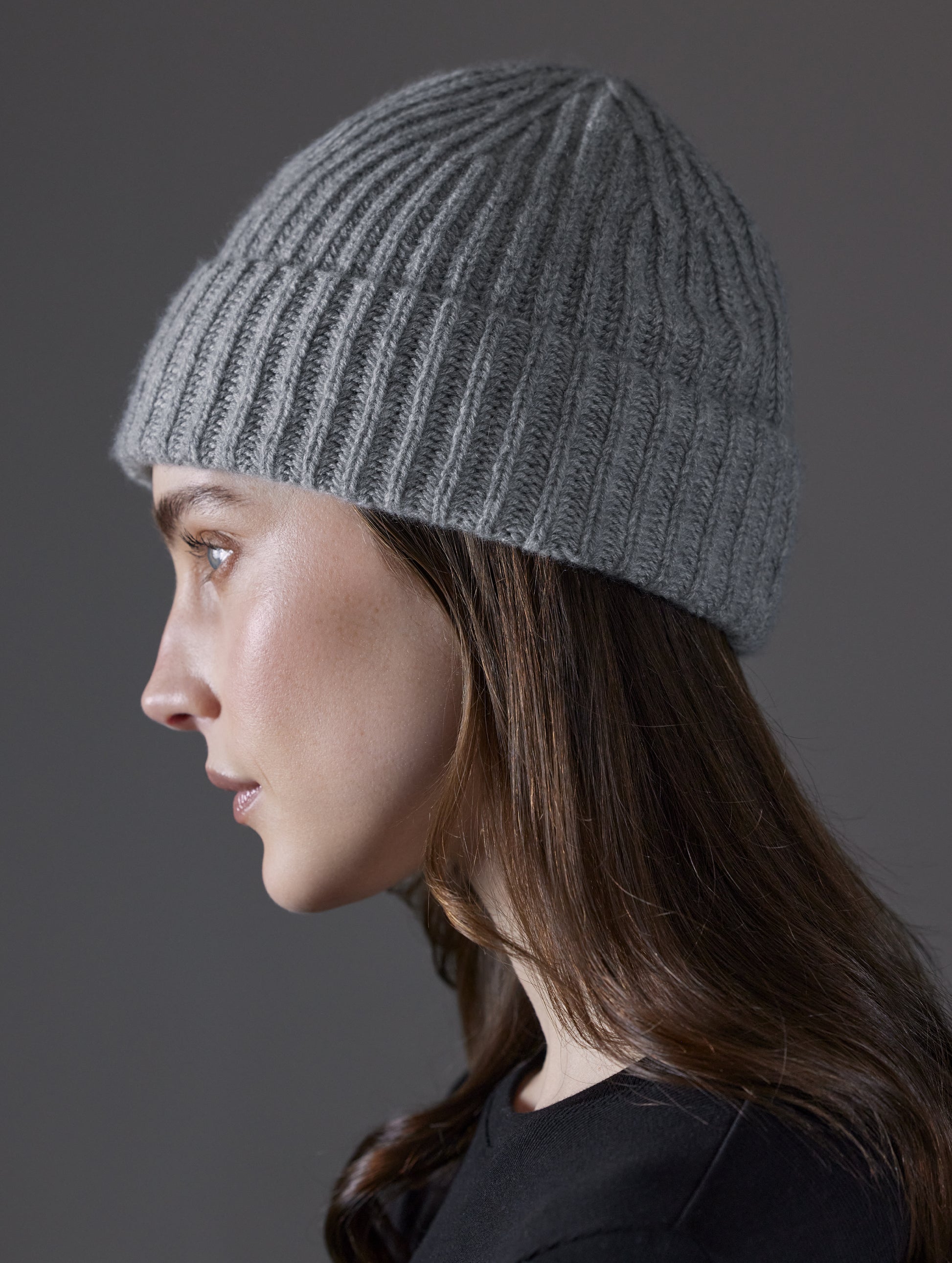 Side profile view of woman wearing Cashmere Hat in Heather Grey from AETHER Apparel.