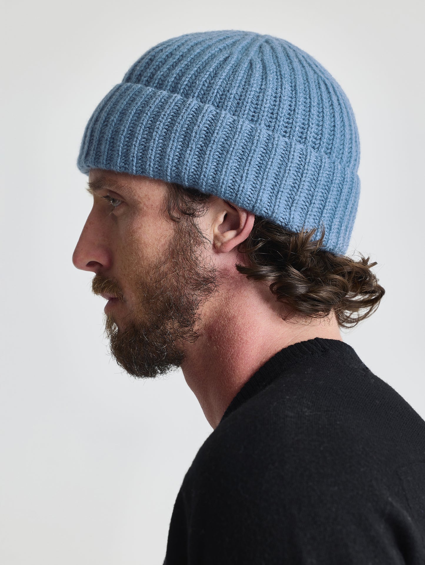 Side profile view of man wearing the Cashmere Hat in Portal Blue from AETHER Apparel.