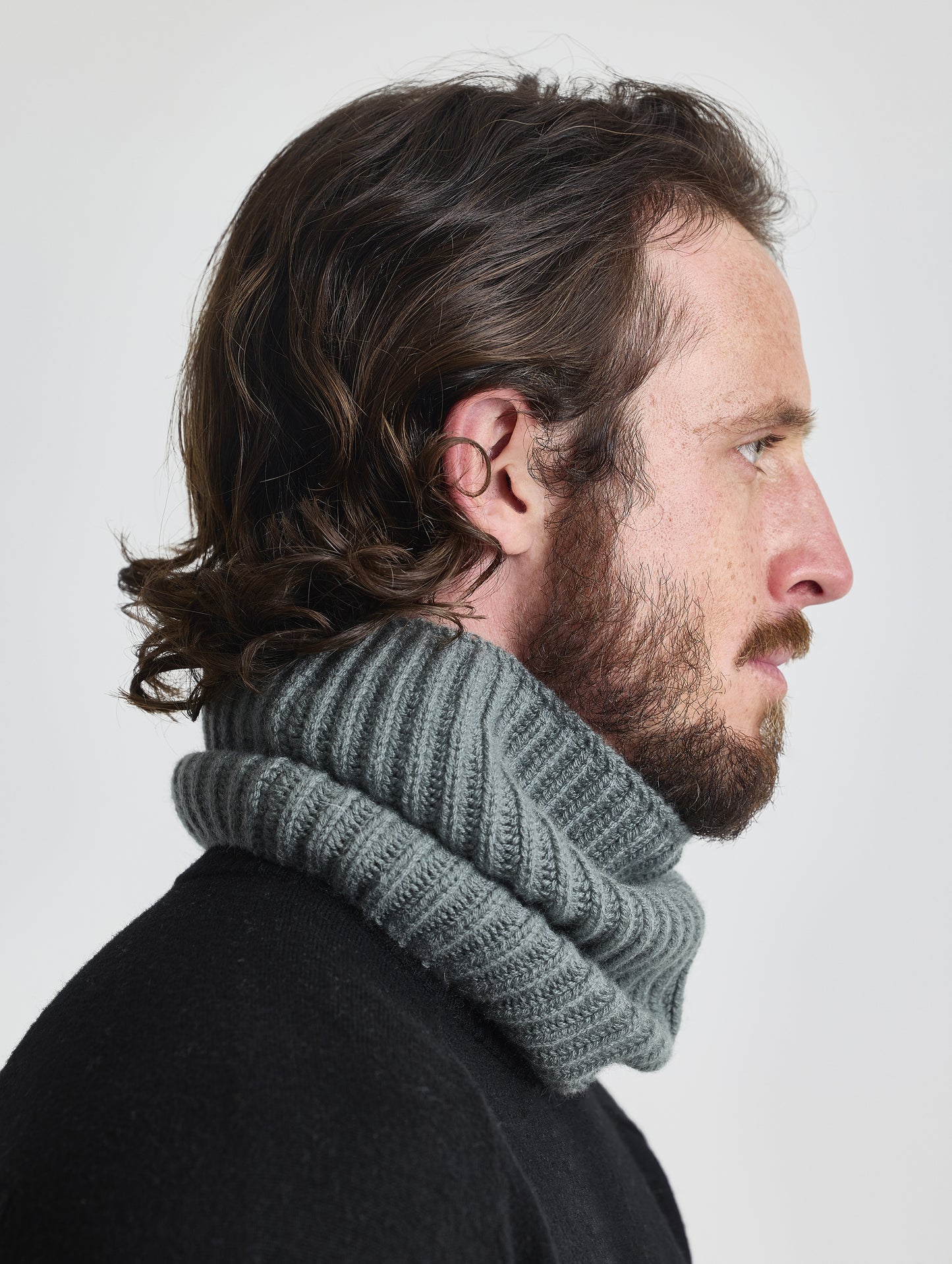 Side profile view of man wearing the Cashmere Neck Gaiter in Gunmetal from AETHER Apparel.