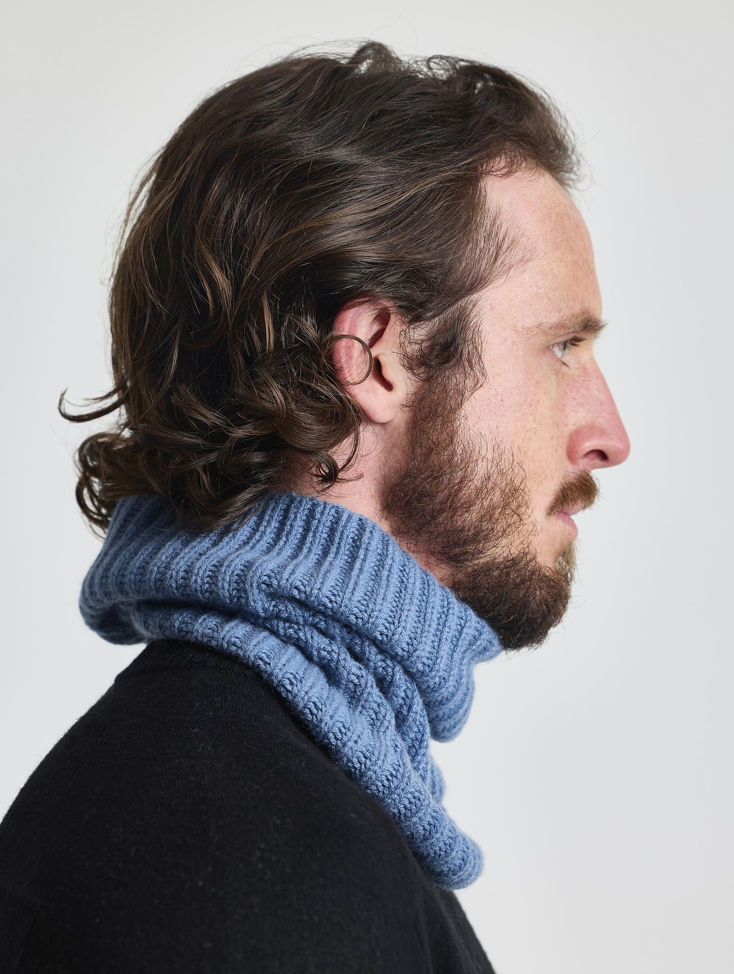 Side profile view of man wearing the Cashmere Neck Gaiter in Portal Blue from AETHER Apparel.