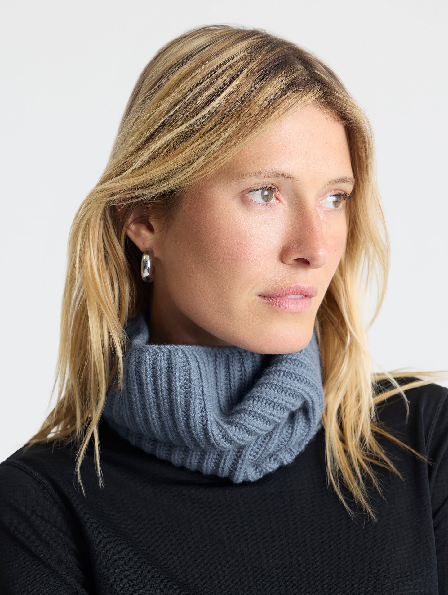 Front angled view of woman wearing the Cashmere Neck Gaiter in Portal Blue from AETHER Apparel.