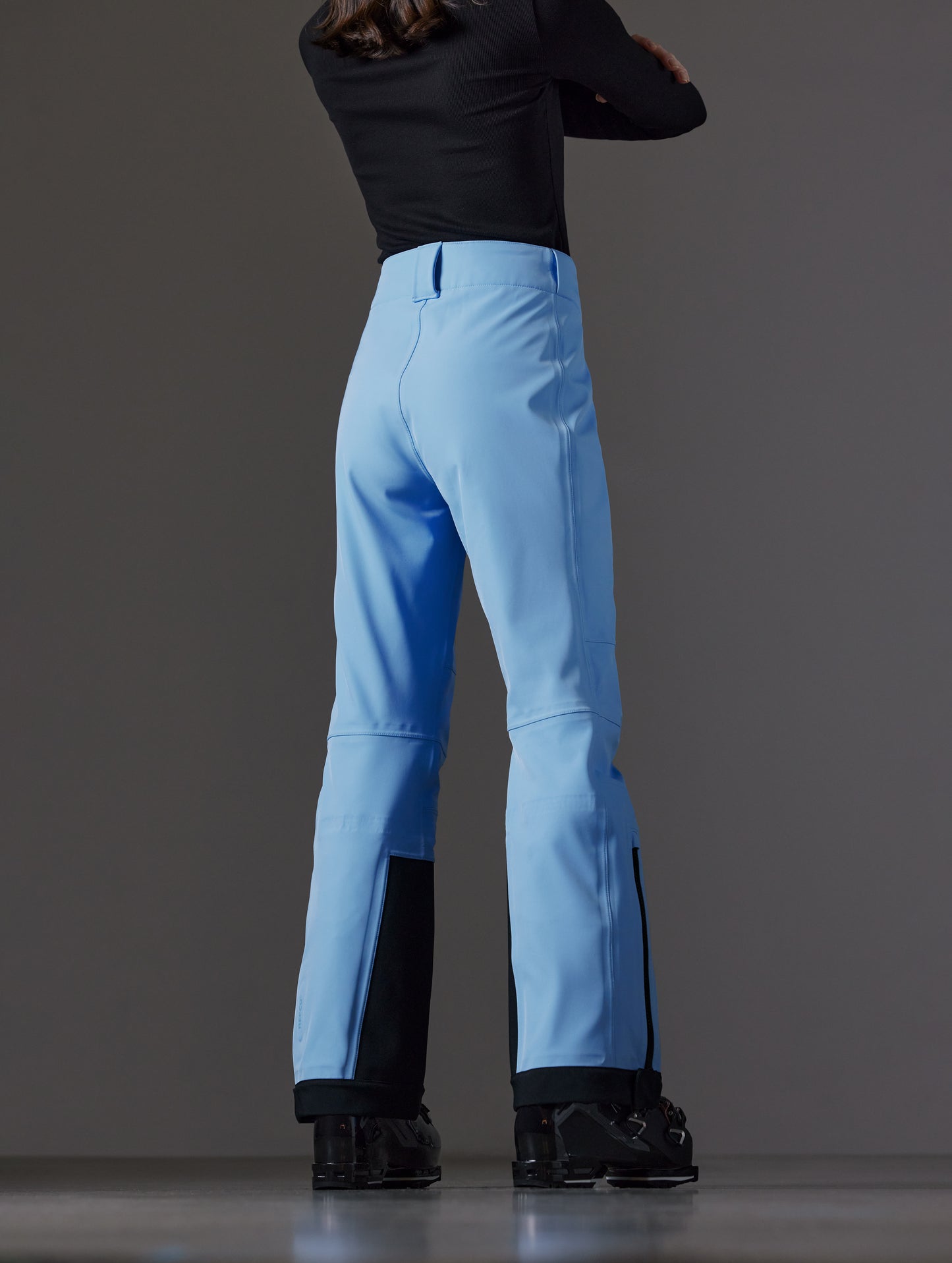Rear angled lower body view of woman wearing Descent Pant in Atlas Blue from AETHER Apparel.