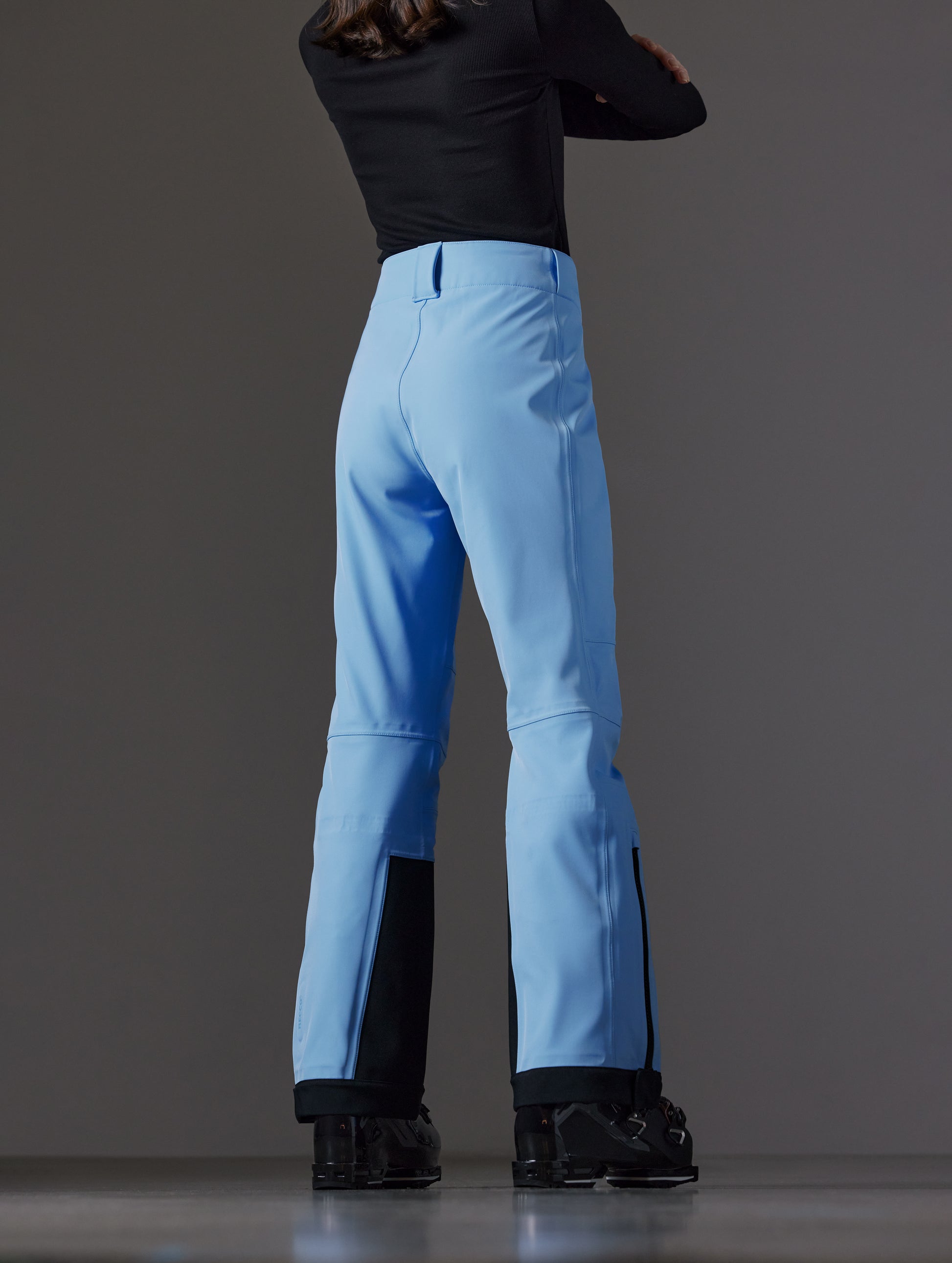 Rear angled lower body view of woman wearing Descent Pant in Atlas Blue from AETHER Apparel.