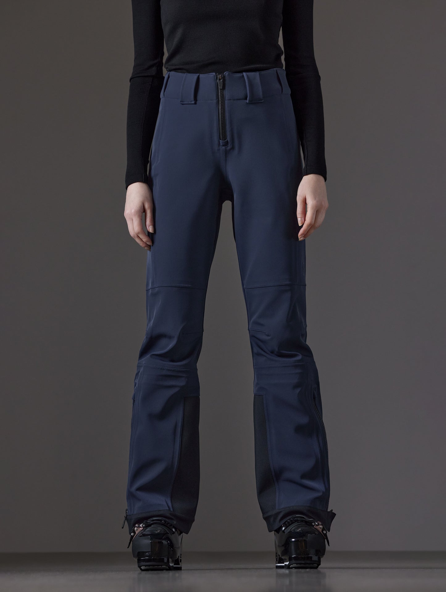 Front lower body view of woman wearing Descent Pant in Total Eclipse dark blue from AETHER Apparel.