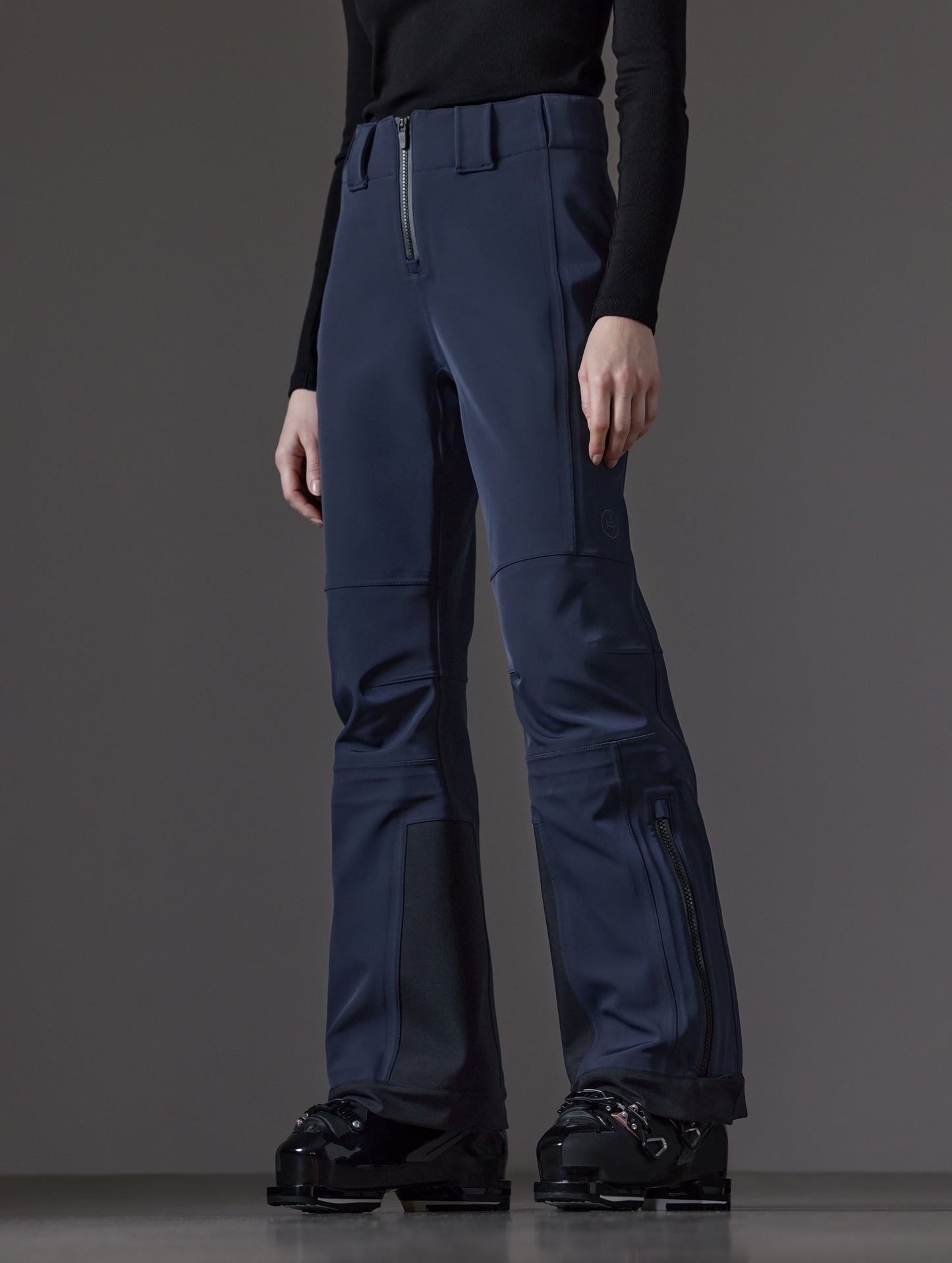 Front angled lower body view of woman wearing Descent Pant in Total Eclipse dark blue from AETHER Apparel.