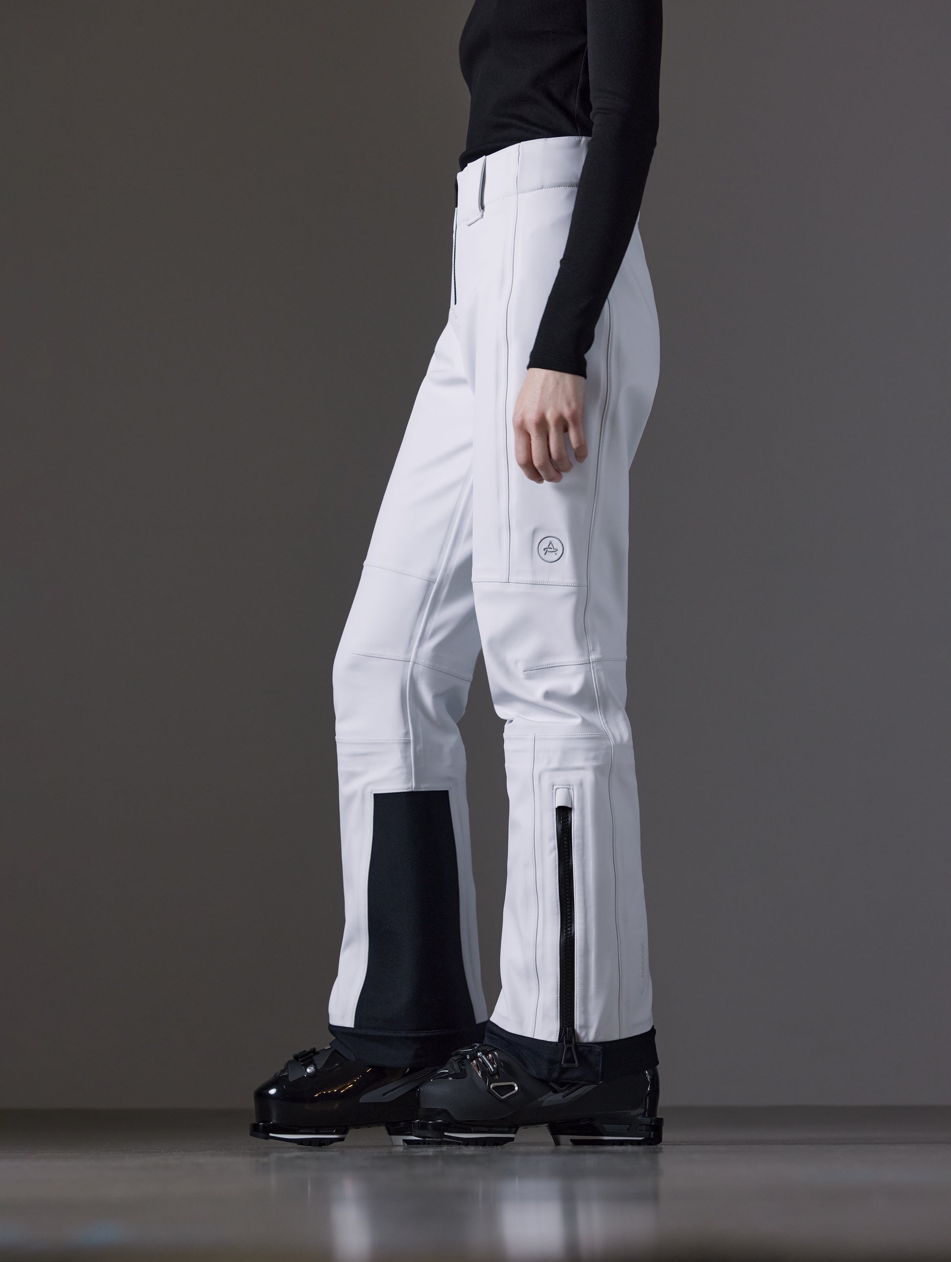 Side profile lower body view of woman wearing Descent Pant in White from AETHER Apparel.