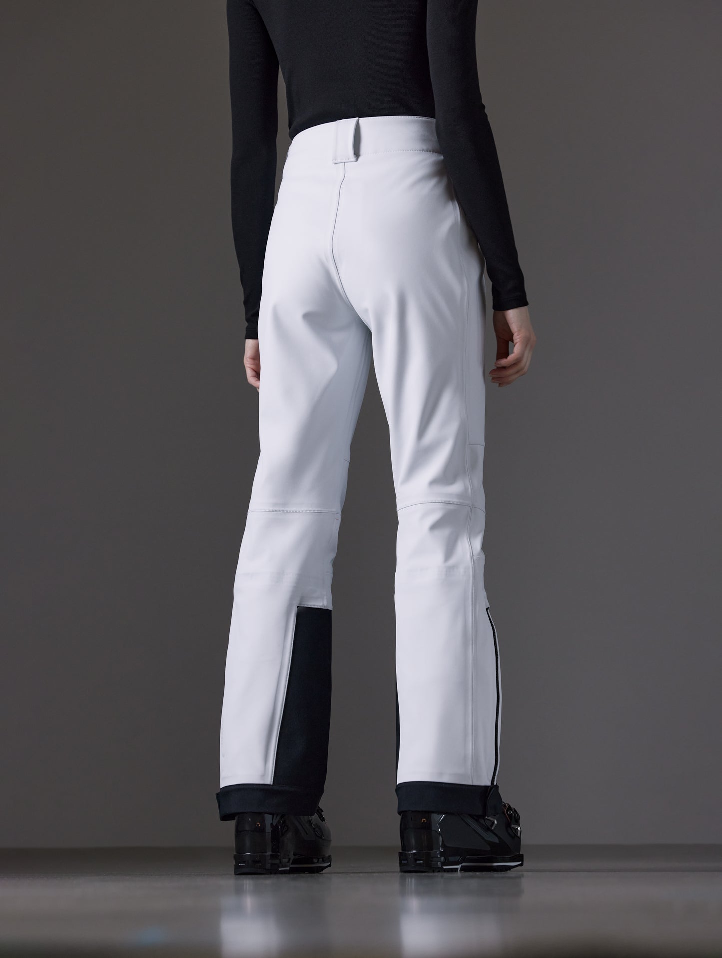 Rear angled lower body view of woman wearing Descent Pant in White from AETHER Apparel.