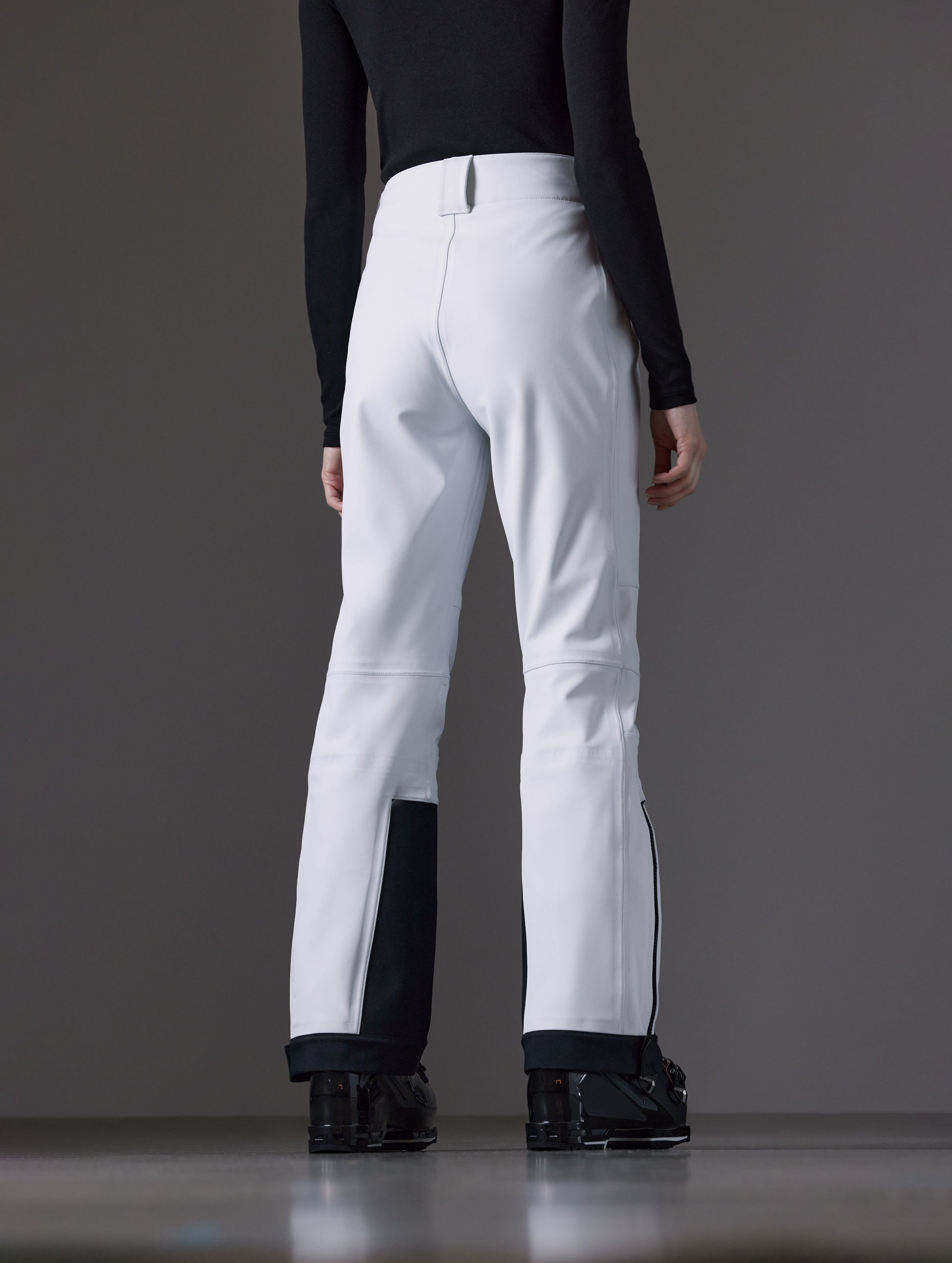 Rear angled lower body view of woman wearing Descent Pant in White from AETHER Apparel.