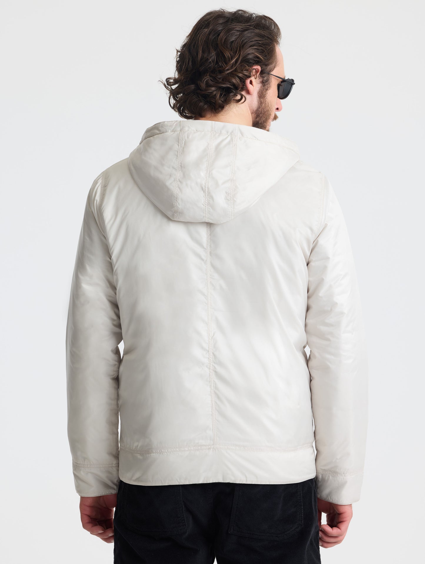 Rear view of man wearing Eco Space Hoodie in Bone white from AETHER Apparel.