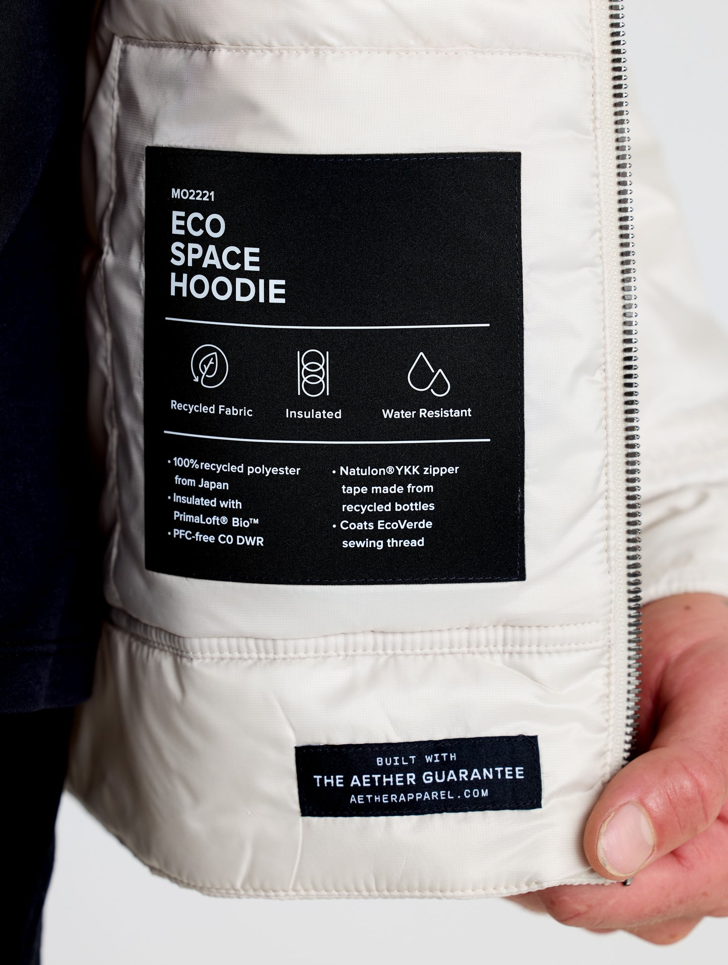Closeup view of interior label of Eco Space Hoodie in Bone white from AETHER Apparel.