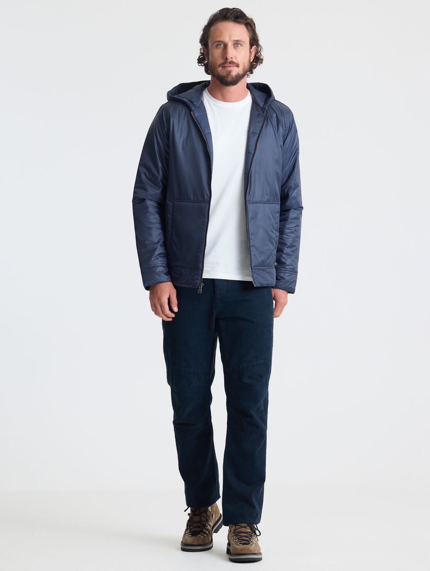 Full body view of man wearing Eco Space Hoodie in Total Eclipse dark blue from AETHER Apparel.
