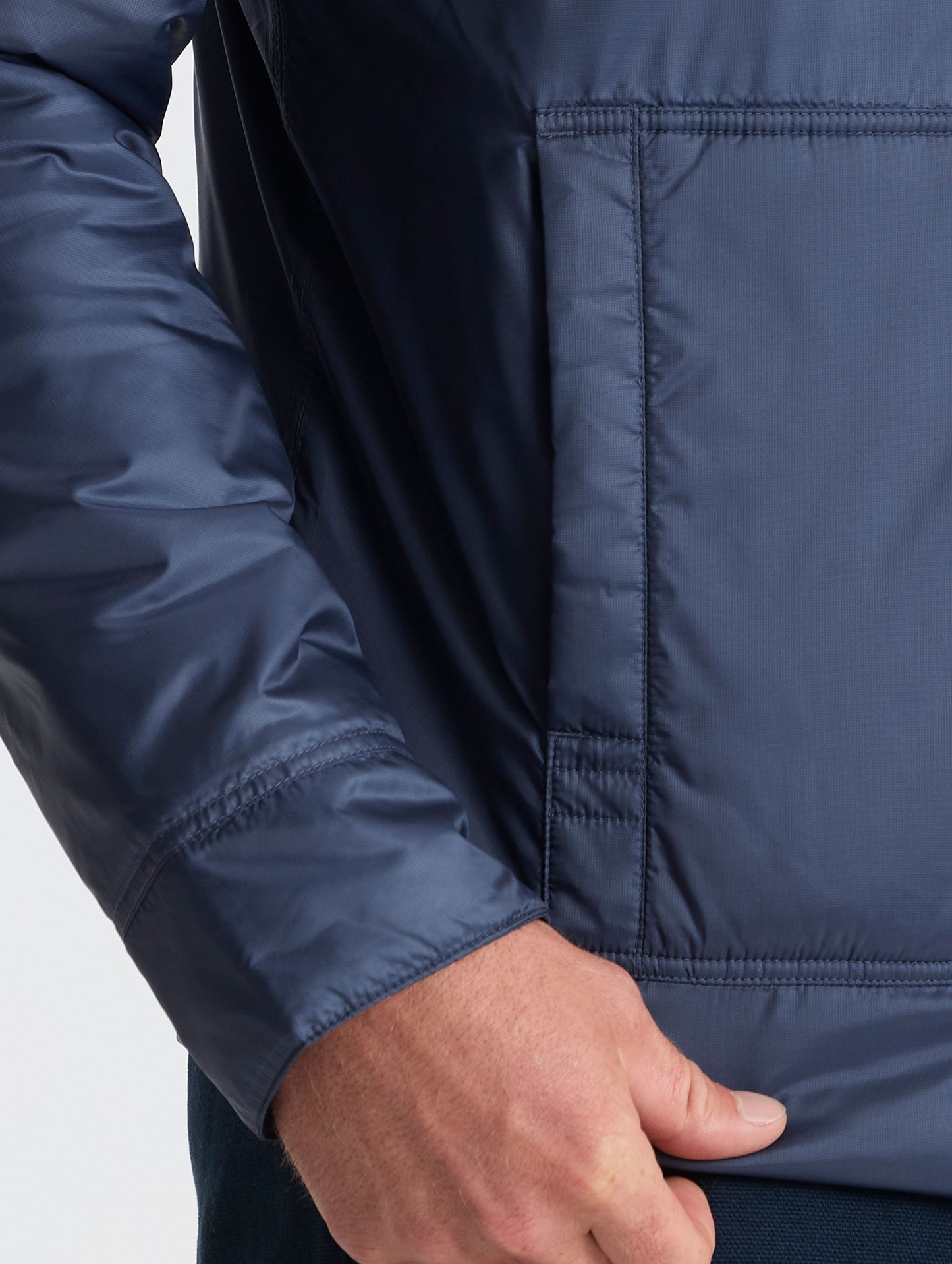 Closeup view of wearer's right hand pocket and sleeve Eco Space Hoodie in Total Eclipse dark blue from AETHER Apparel.