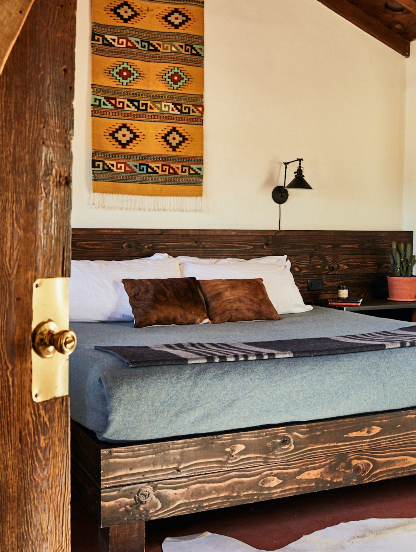 Bedroom with hanging tapestry in Pioneertown Motel in Pioneertown, California.