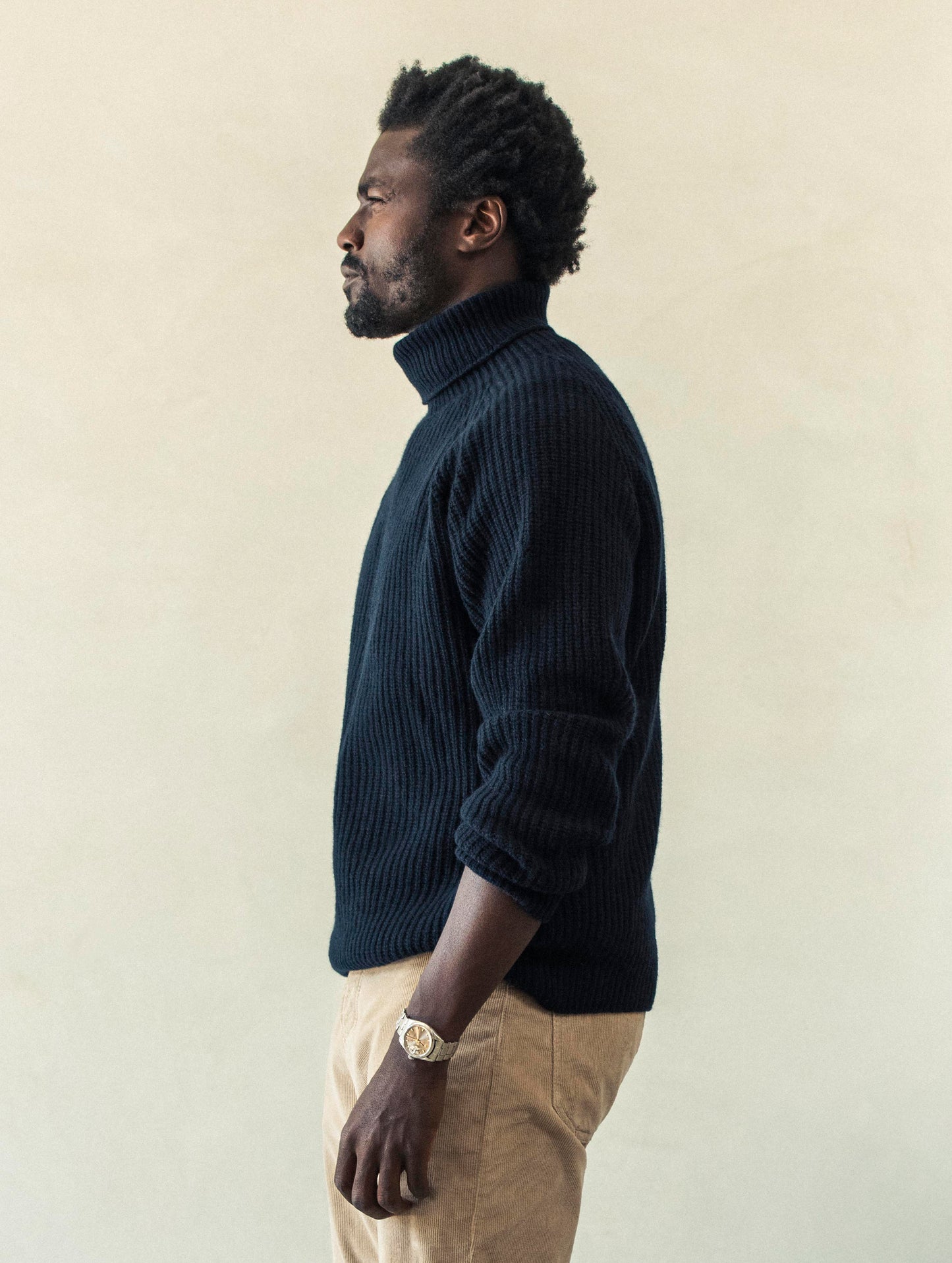 Side profile view of man wearing Finley Sweater in Total Eclipse dark blue from AETHER Apparel.