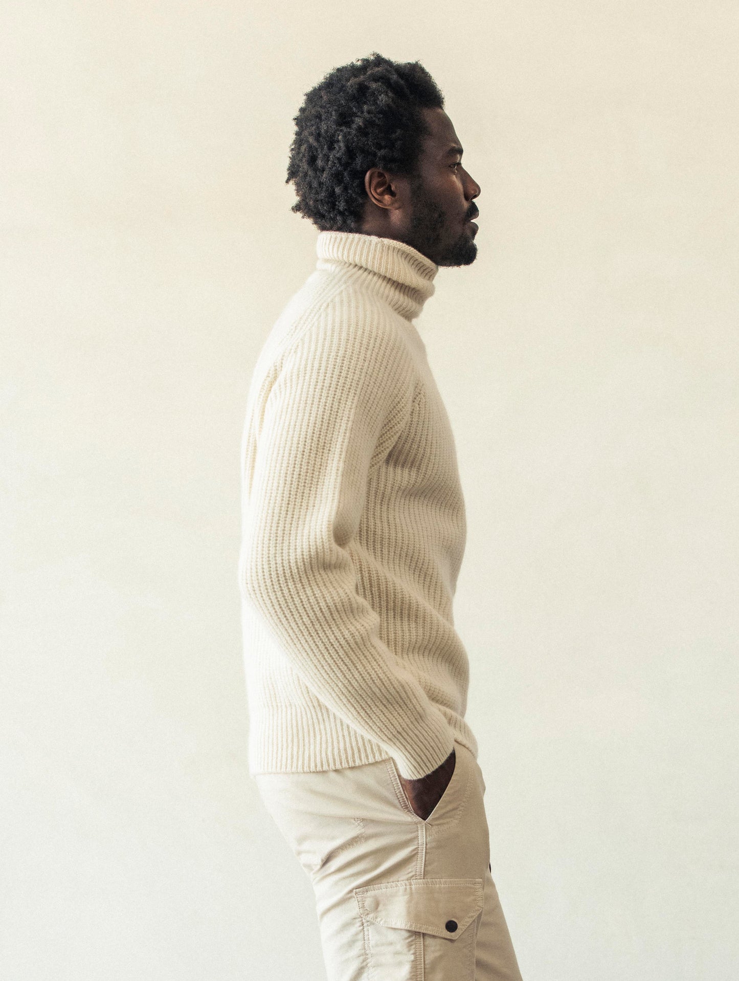Right side profile view of man wearing Finley Sweater in Winter White from AETHER Apparel.